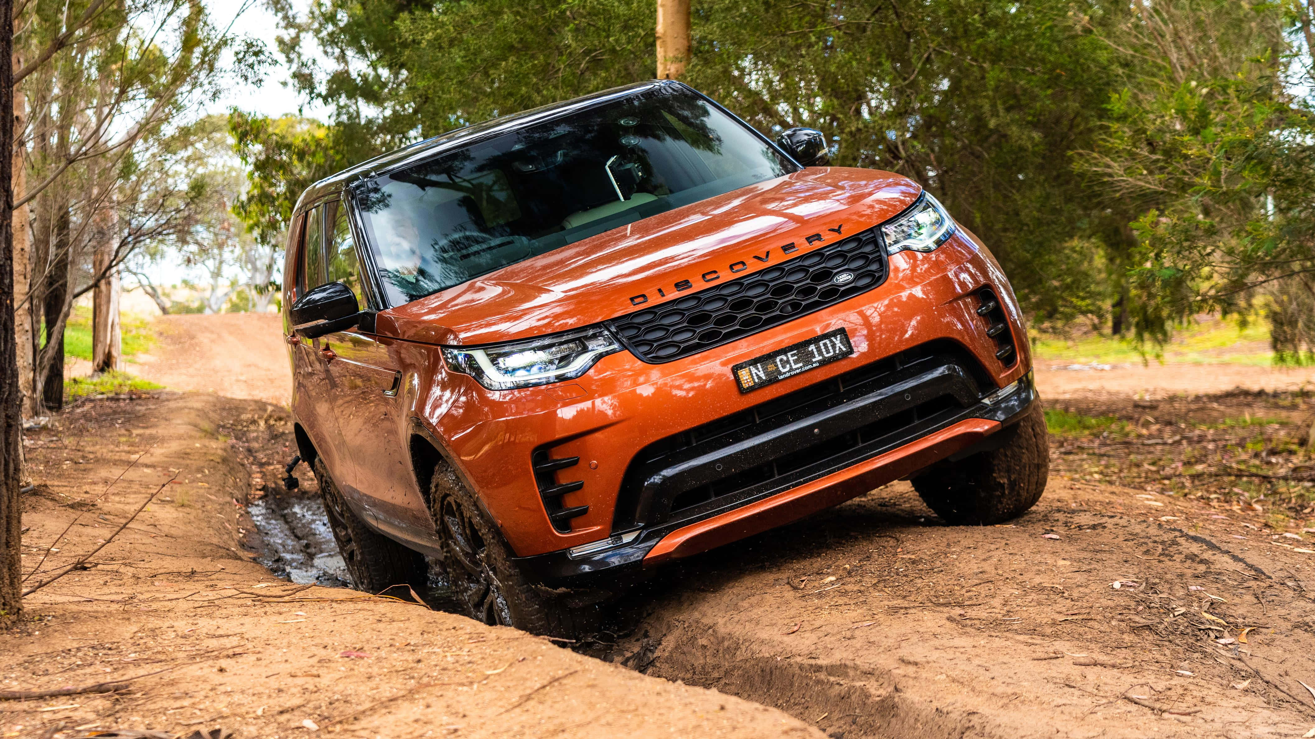Land Rover Discovery, muddy forest trail, vibrant orange, 4K Desktop Wallpaper