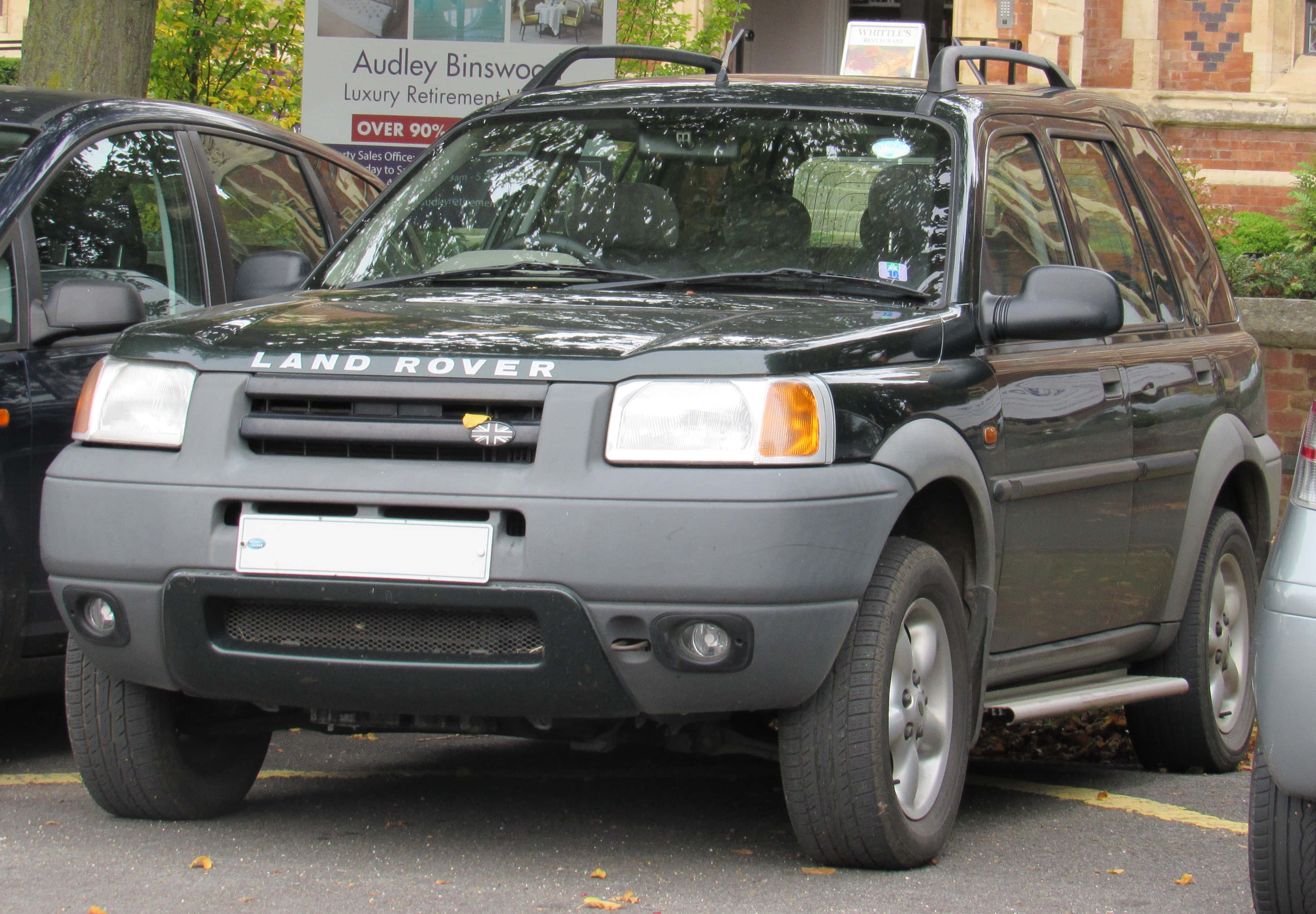 Land Rover Freelander, dark gray, leaf-strewn urban lot, 2K Desktop Wallpaper