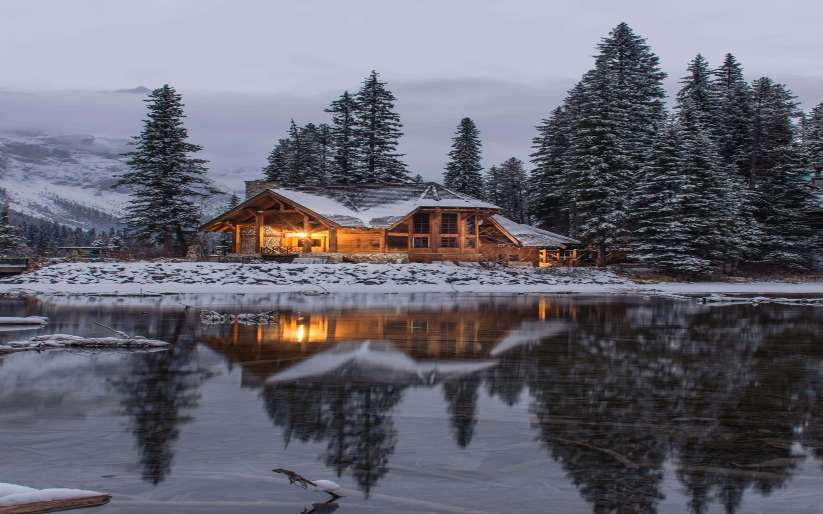 Laptop in the Wintery Wonderland, wooden cabin, snow-dusted lake, 2K Desktop Wallpaper