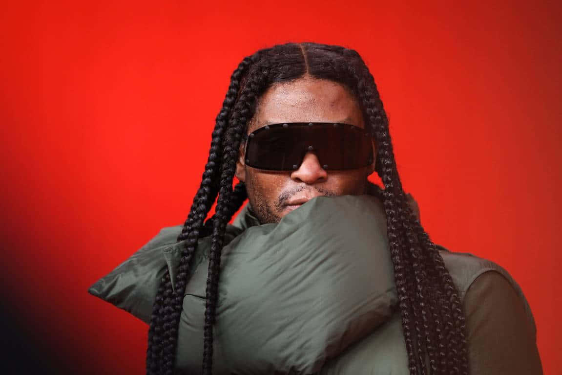 Law Roach, green puffer jacket, vivid red background, SD Desktop Wallpaper