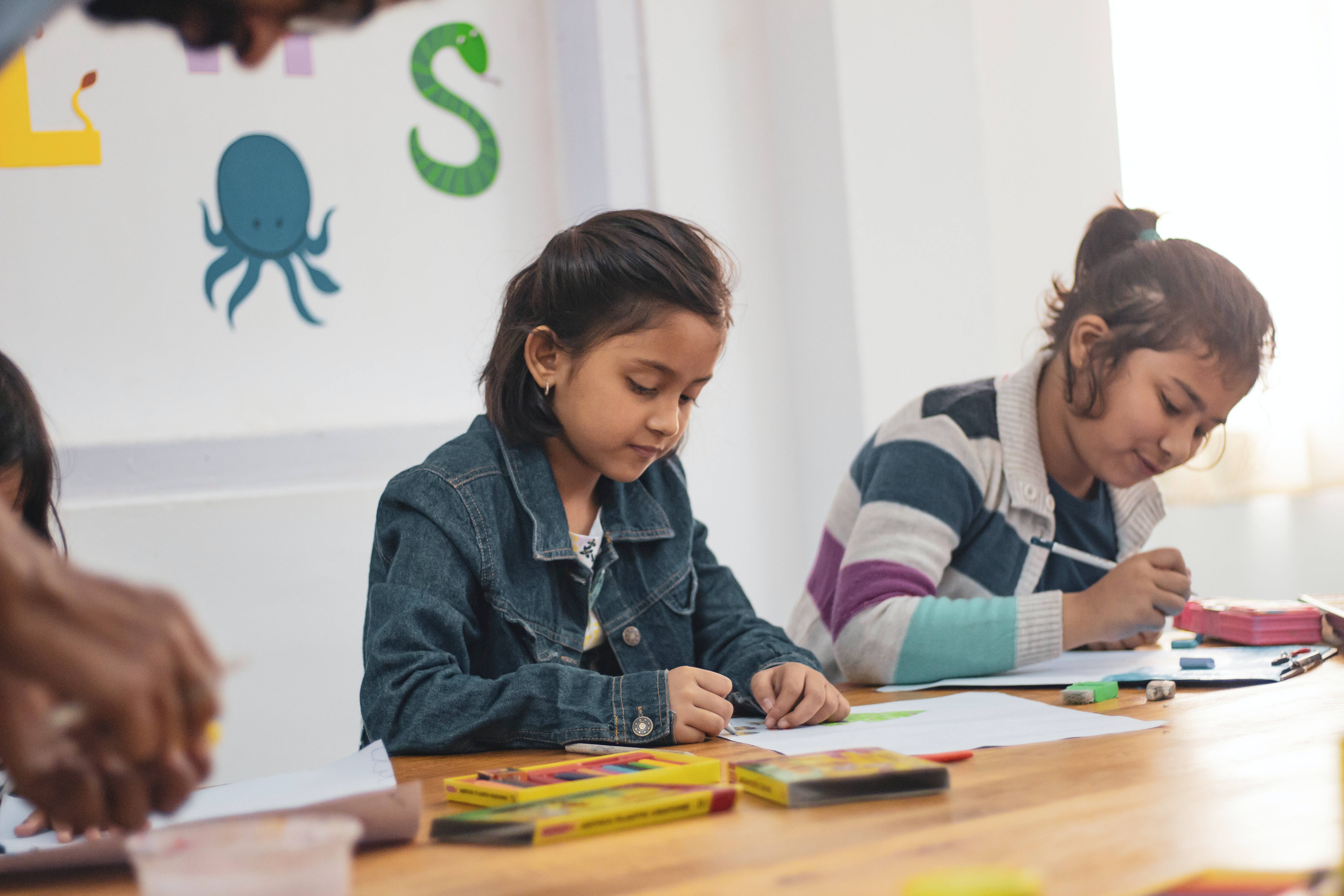 two young girls, wooden table, bright classroom, 5K Desktop Wallpaper