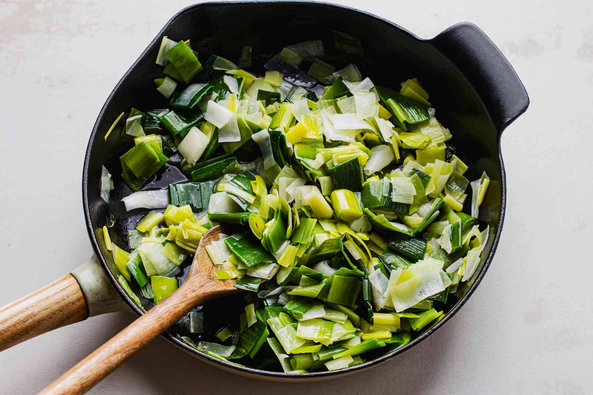 black cast iron skillet, wooden spoon, freshly chopped leeks, Full HD Desktop Wallpaper
