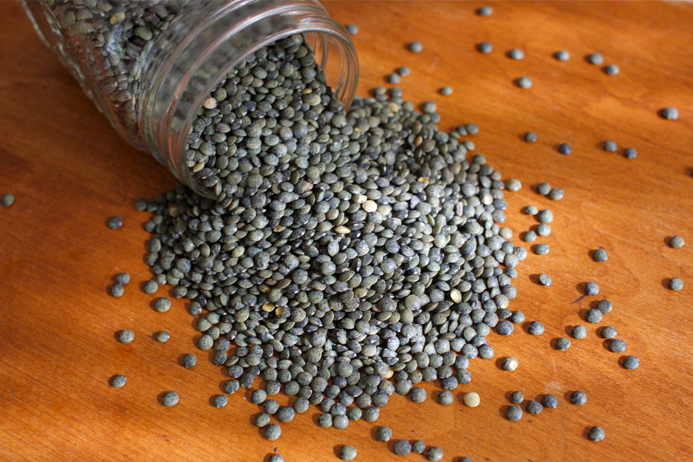 glass jar, dark gray lentils, warm wooden surface, Full HD Desktop Wallpaper