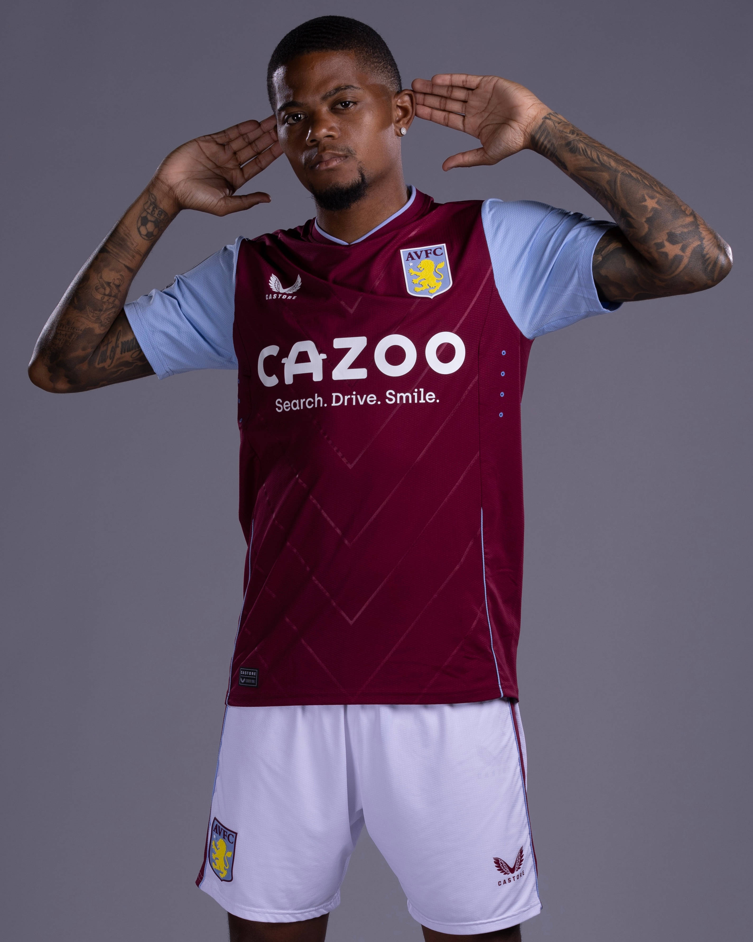 Leon Bailey, maroon and light blue Aston Villa jersey, plain gray studio background, 2K Phone Wallpaper