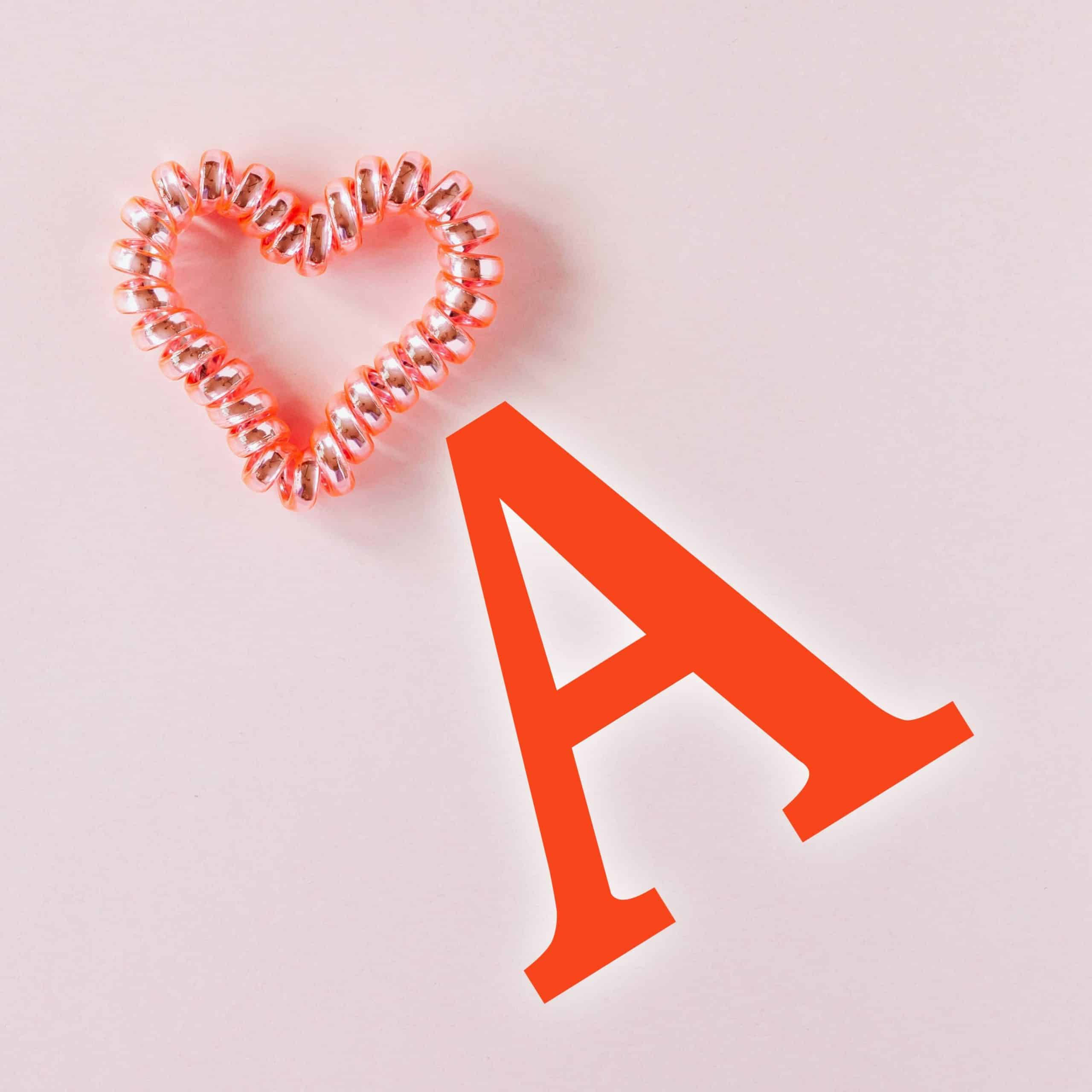 red a, coral heart-shaped hair tie, bold orange letter a, 2K Desktop Wallpaper