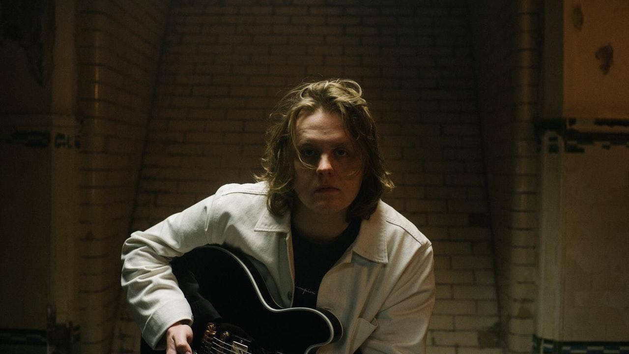 Lewis Capaldi, black electric guitar, dim brick wall, HD Desktop Wallpaper