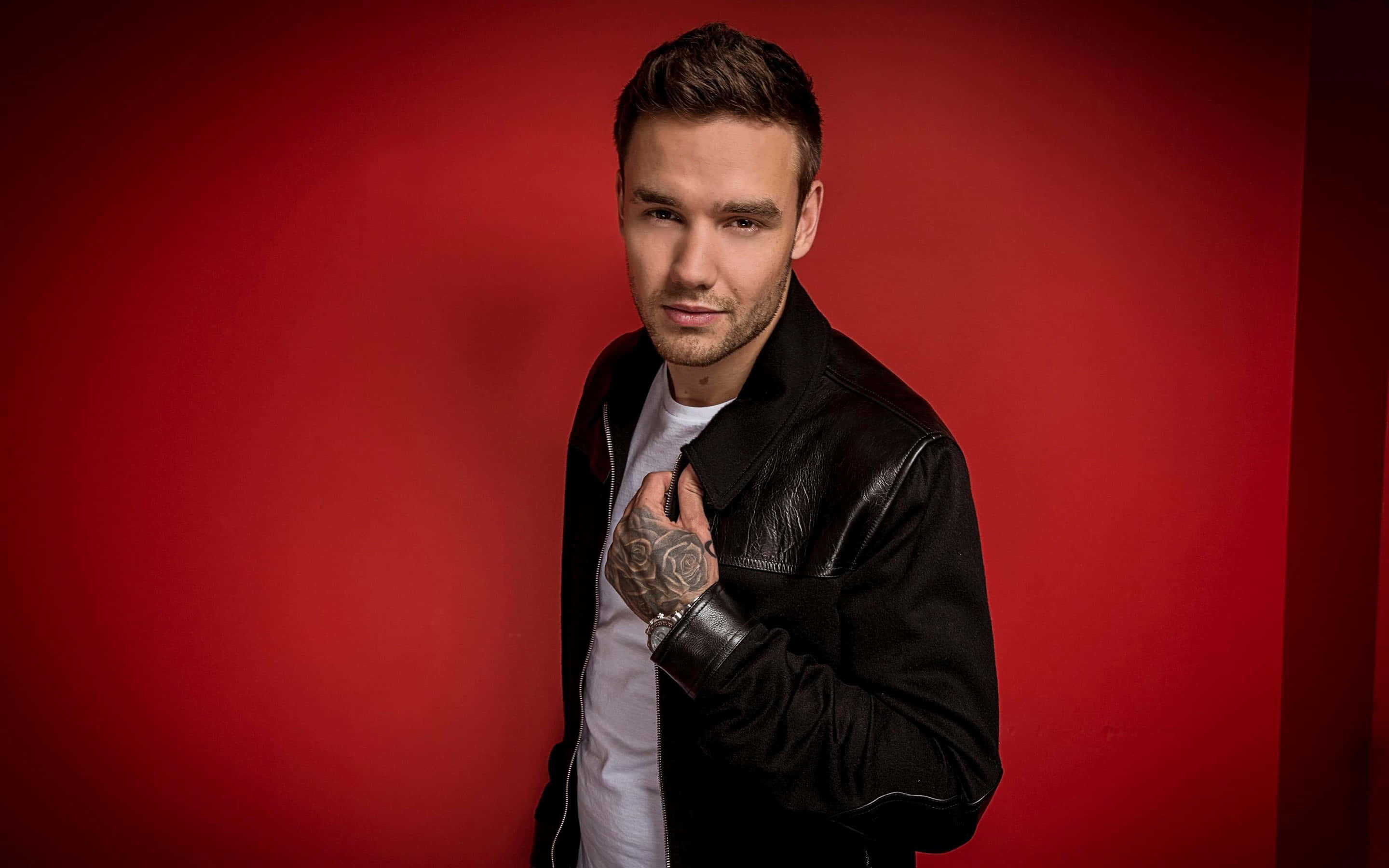 Liam Payne, leather jacket, vibrant red studio backdrop, 2K Desktop Wallpaper
