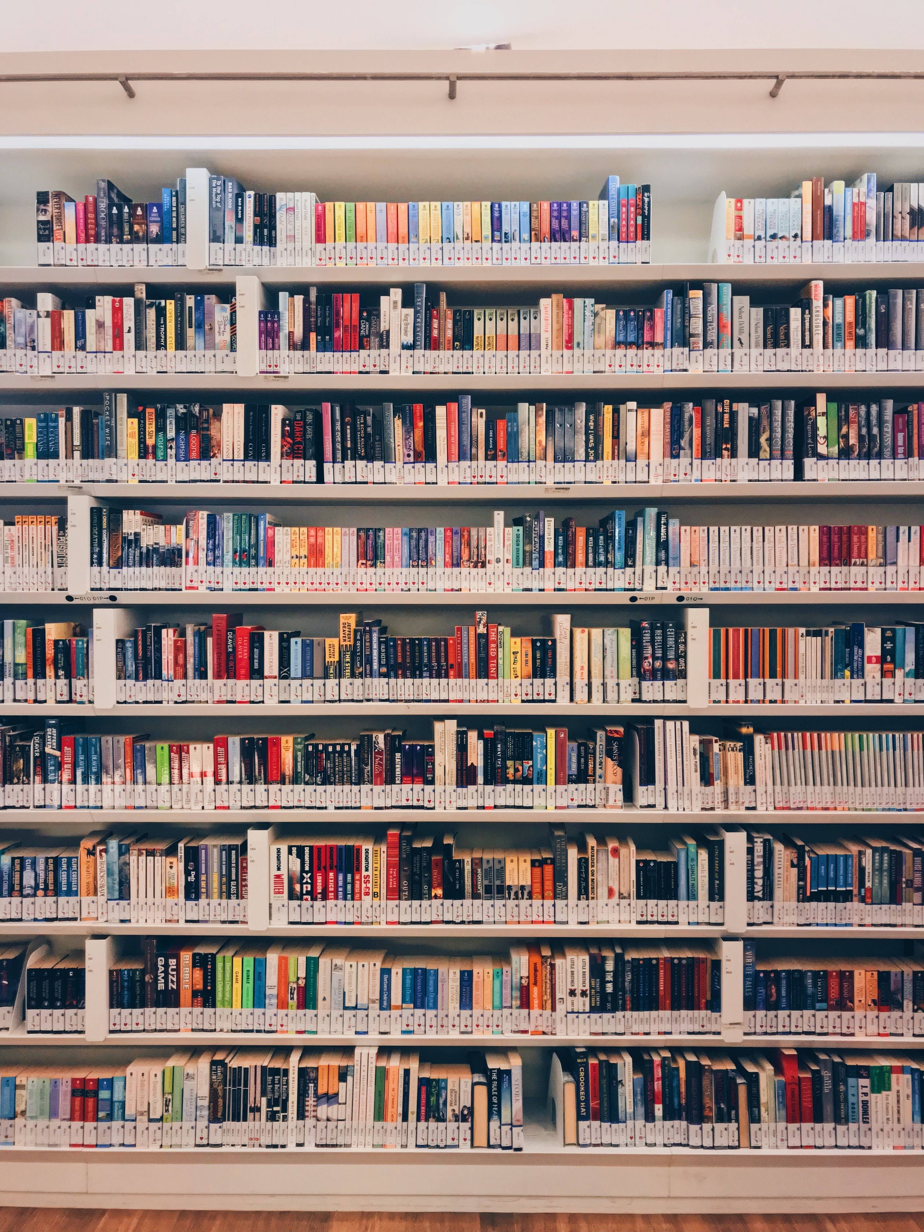 library, white shelves, vibrant spines, 4K Phone Wallpaper