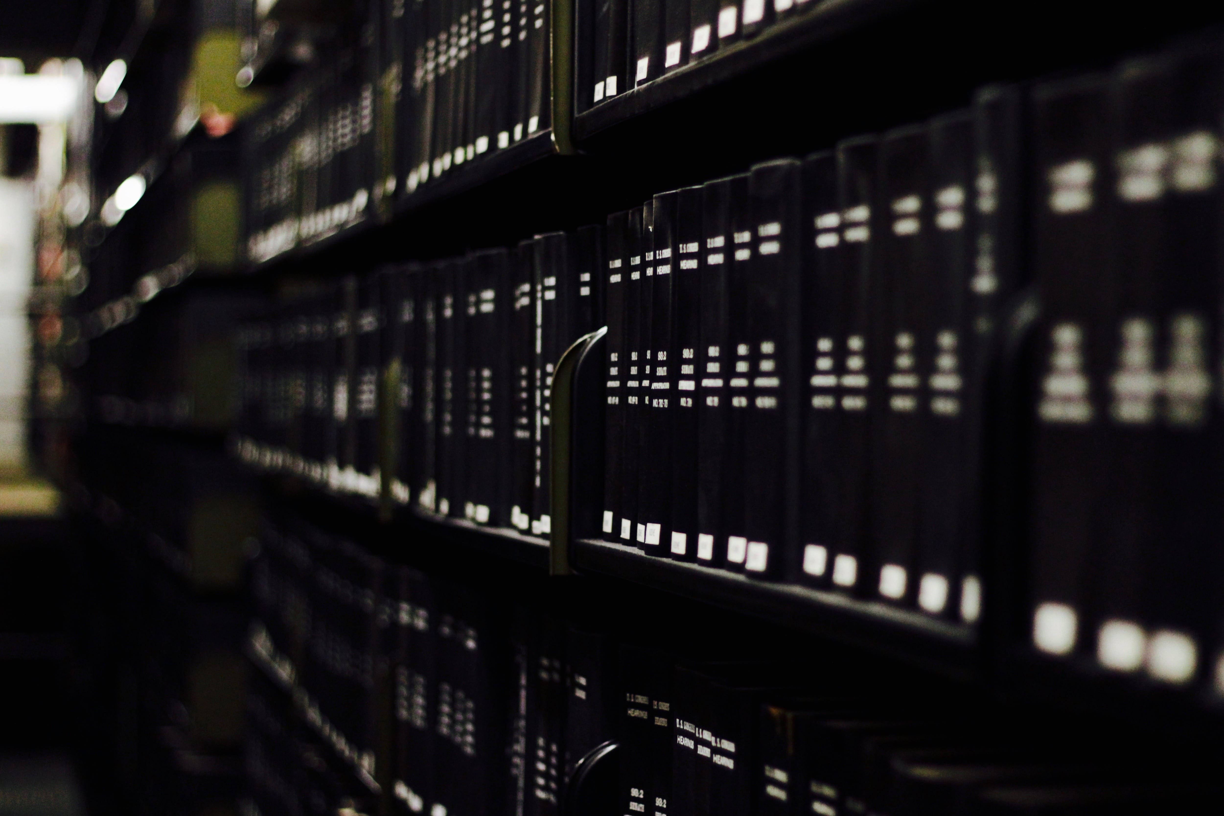 black law books, white lettering, dimly lit library shelves, 4K Desktop Wallpaper