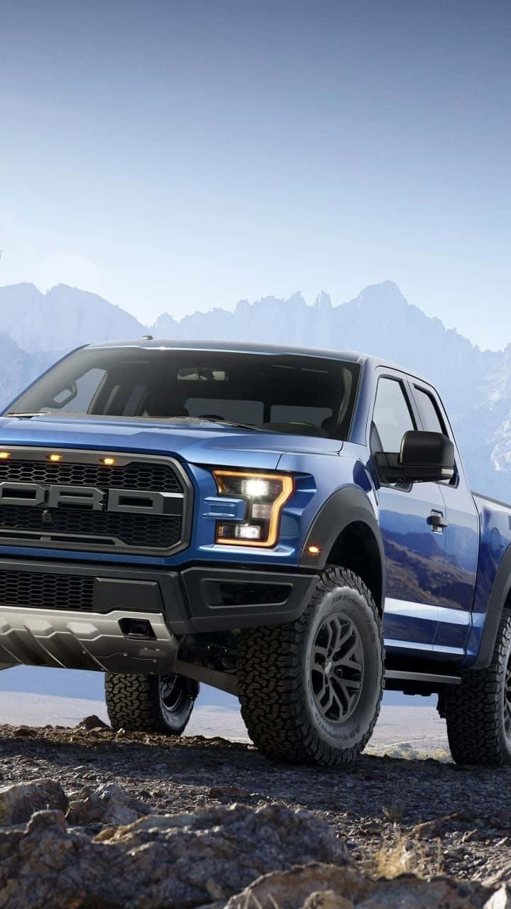 blue Ford F-150 Raptor, rocky terrain, snow-capped mountains, HD Phone Wallpaper