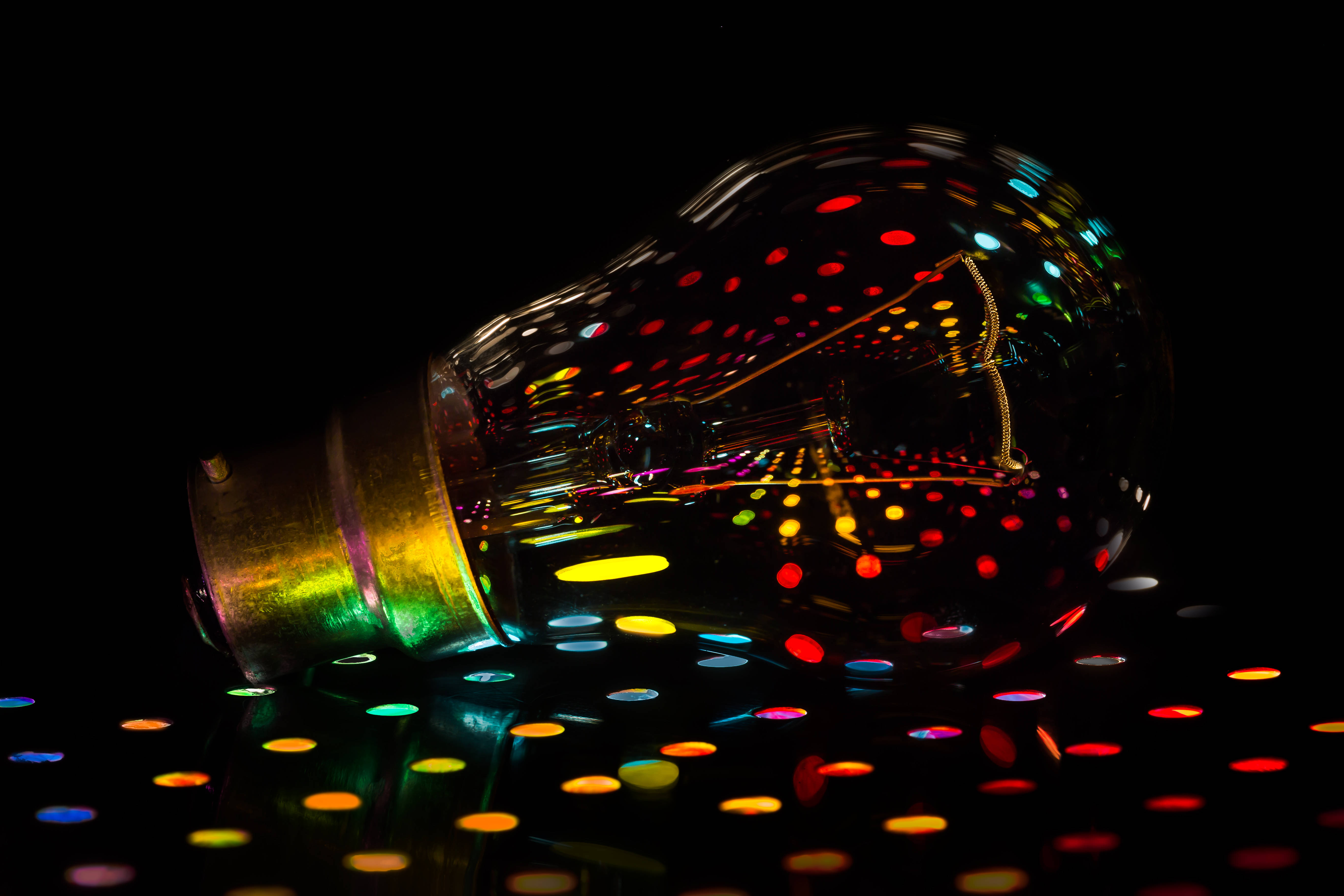 shattered disco ball light bulb, rainbow glitter dots, black surface, 5K Desktop Wallpaper
