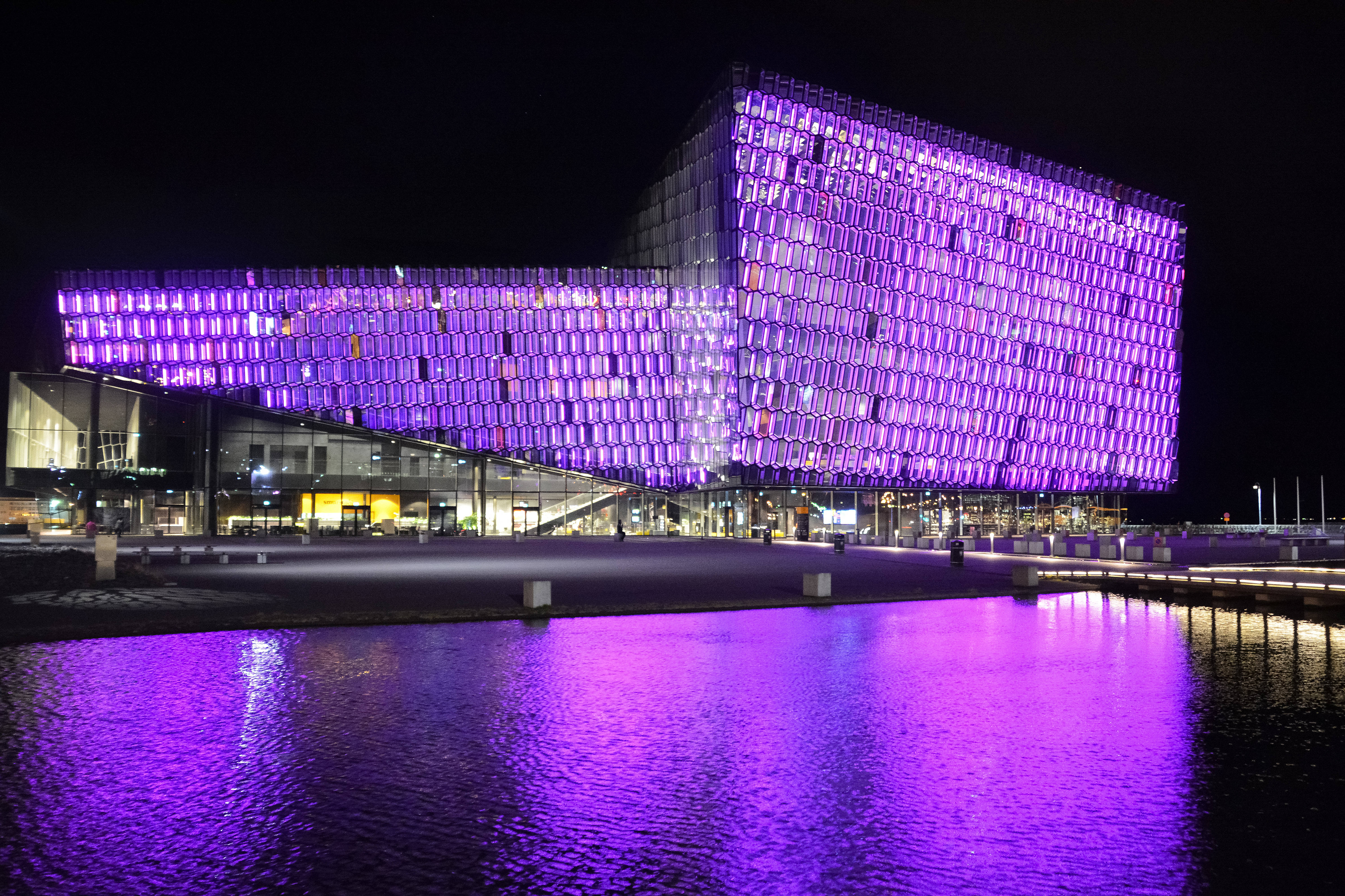 modern building, grid of glowing purple lights, calm water feature, 5K Desktop Wallpaper