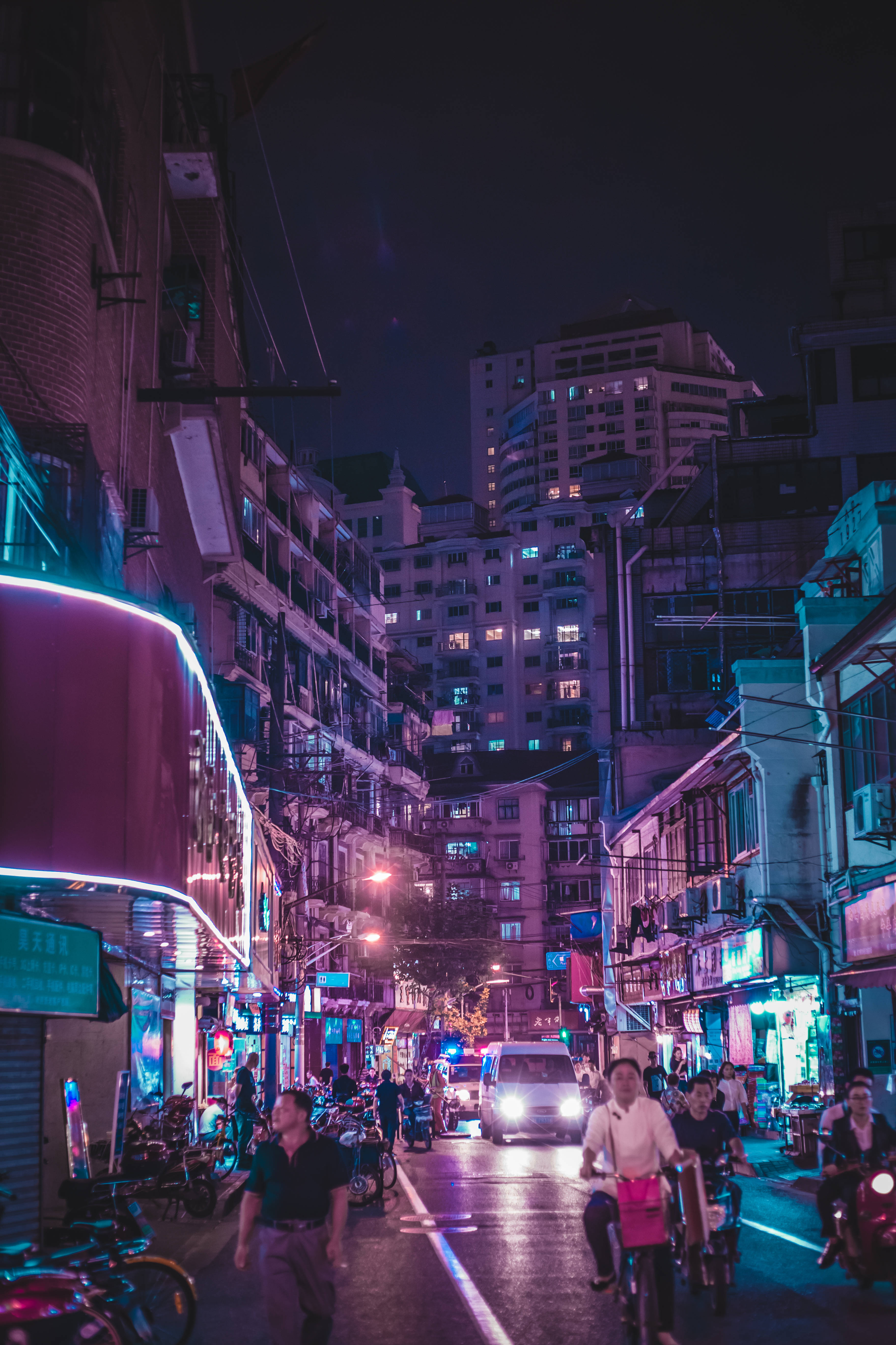 neon-lit urban alley, night, people riding bikes, 5K Phone Wallpaper