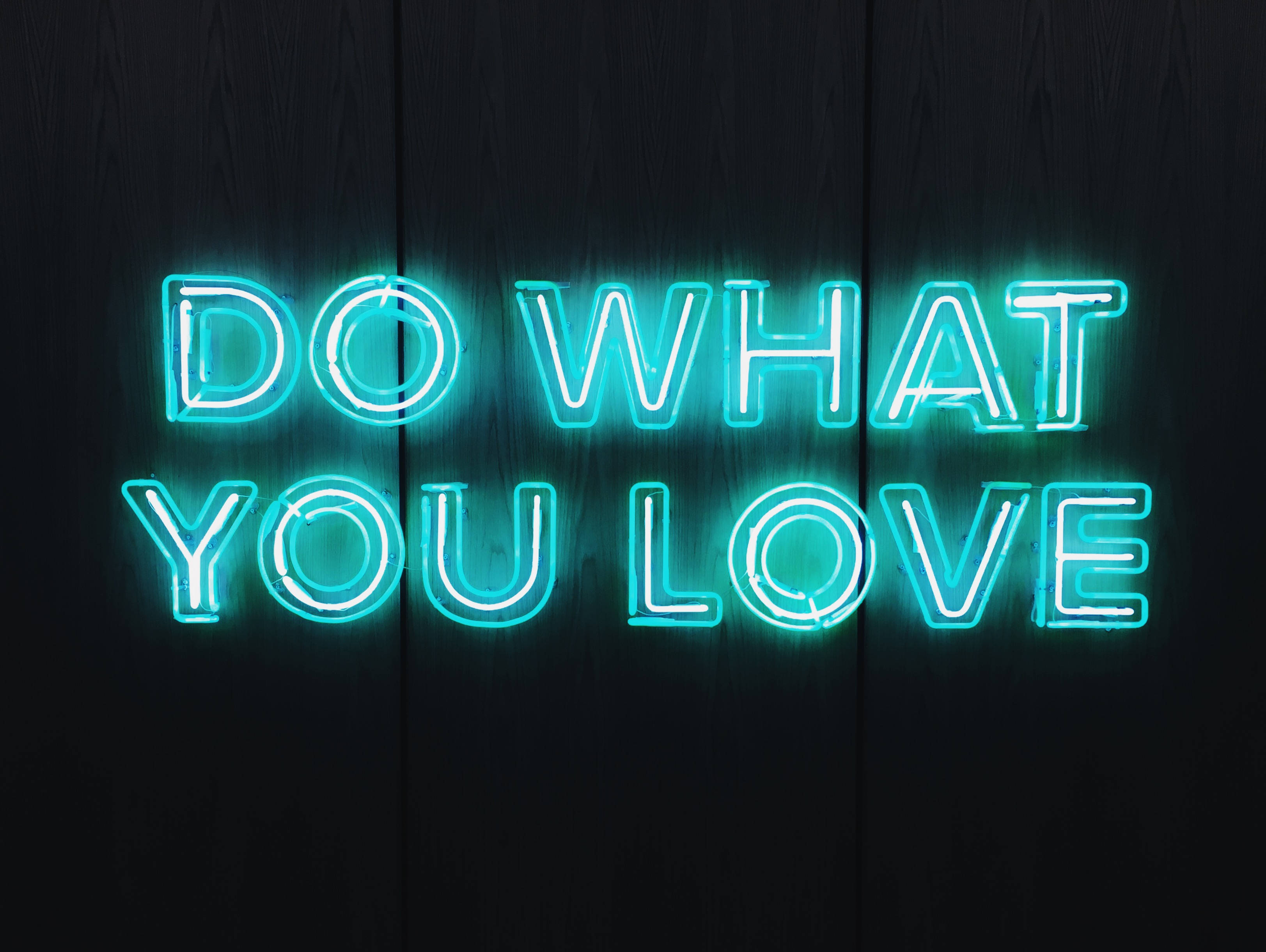 DO WHAT YOU LOVE, glowing cyan neon sign, dark wooden wall, 2K Desktop Wallpaper