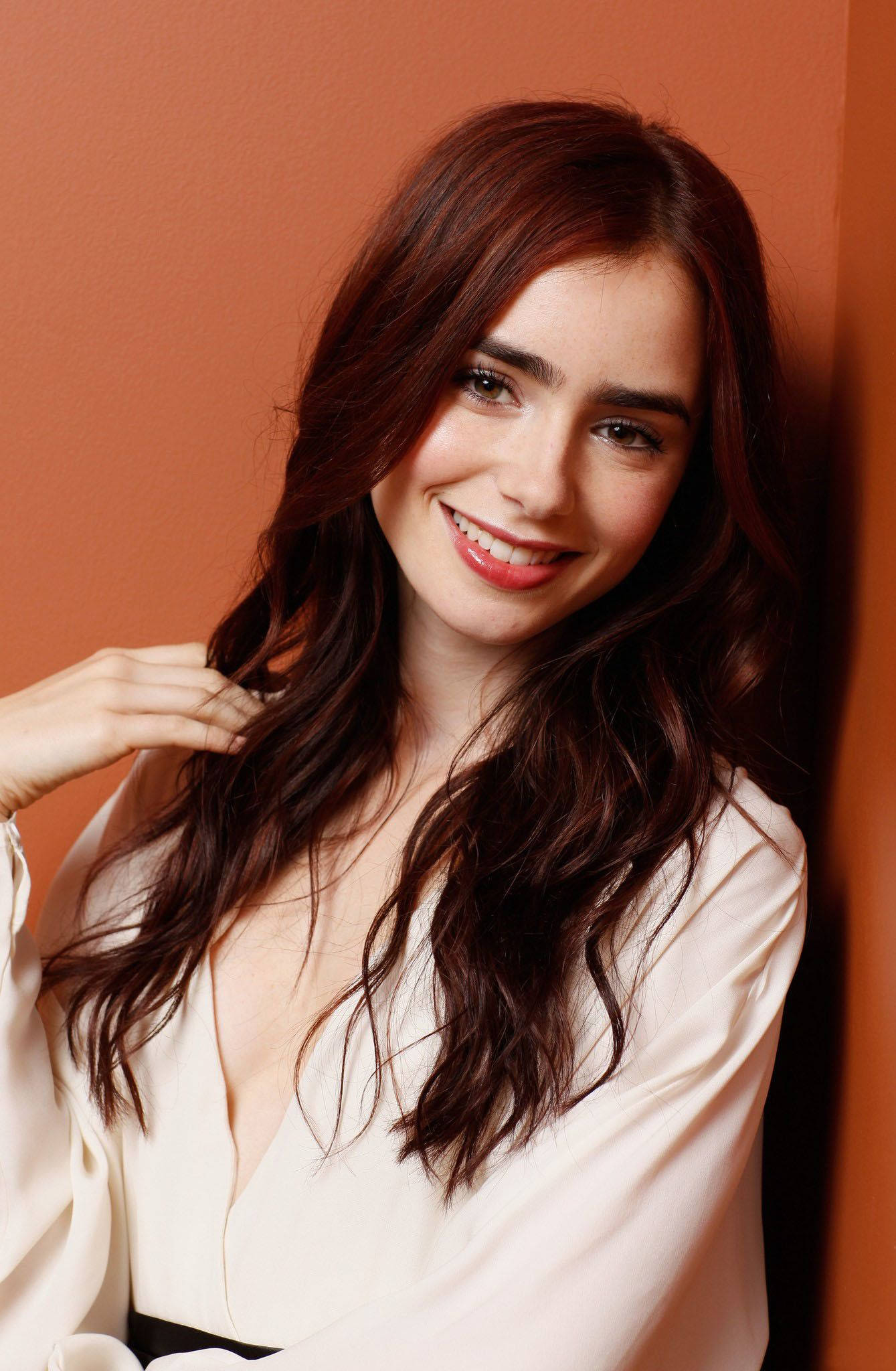 Lily Collins, long dark hair, warm terracotta wall, Full HD Phone Wallpaper