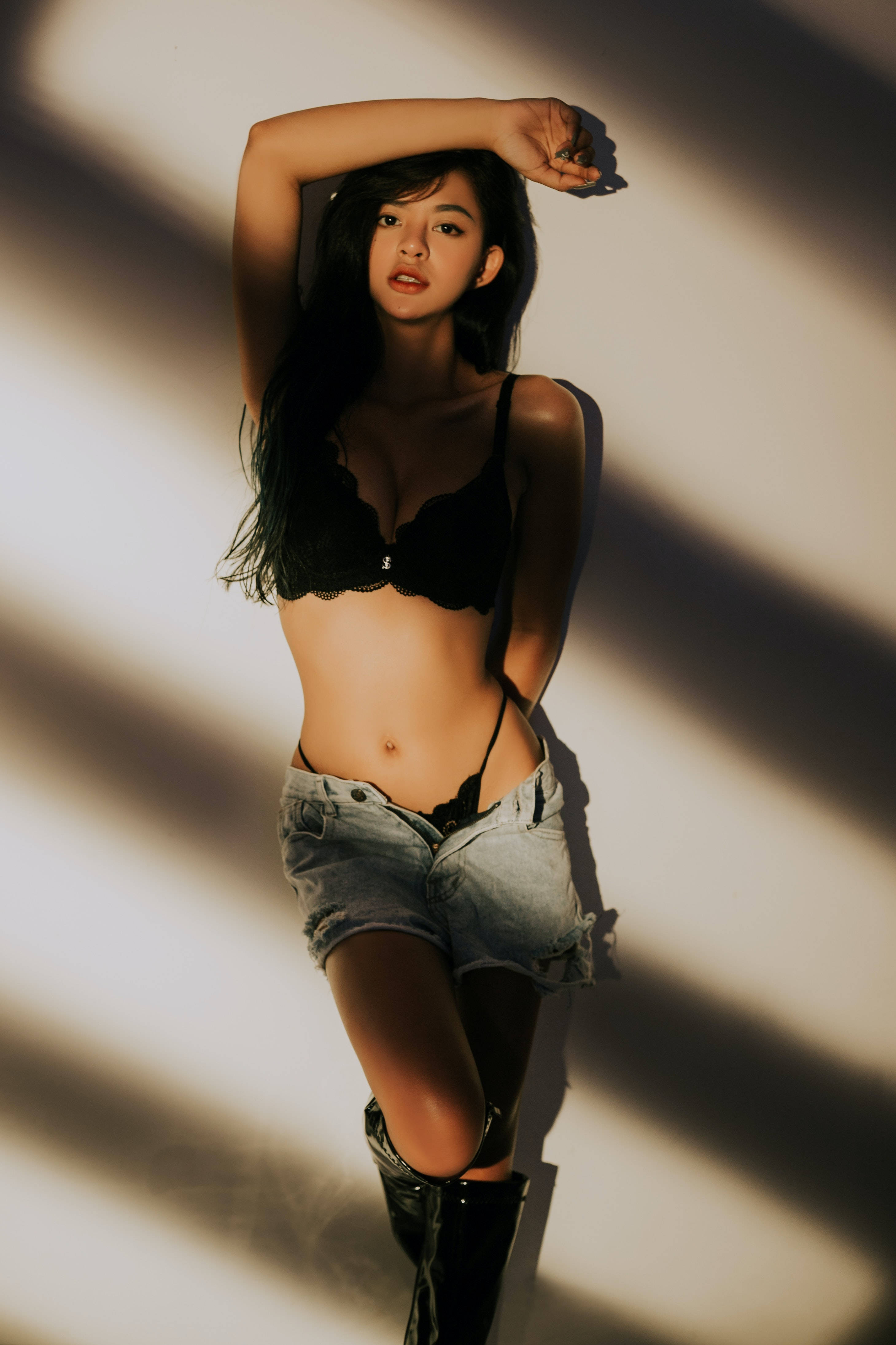 black lingerie, denim shorts, dramatic diagonal light and shadow stripes, 4K Phone Wallpaper