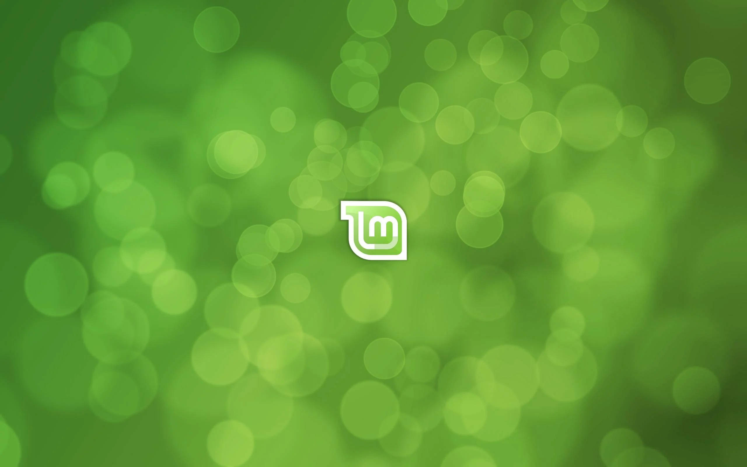 Linux Mint 9, green bokeh background, white stylized logo, 2K Desktop Wallpaper