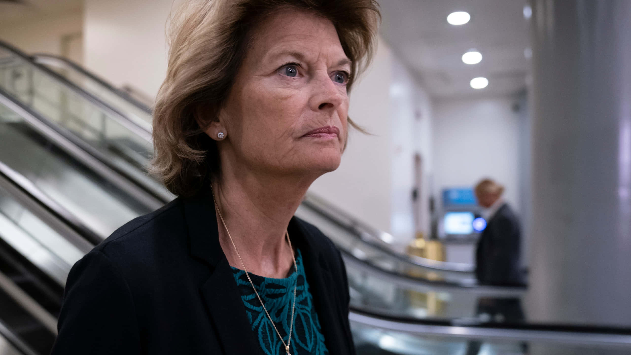 Lisa Murkowski, escalators, modern indoor setting, 2K Desktop Wallpaper