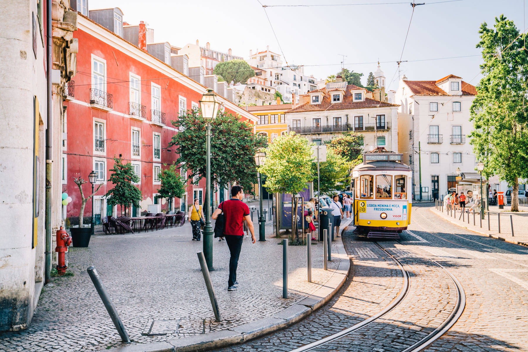 yellow tram, sunlit cobblestone street, colorful buildings, HD Desktop Wallpaper