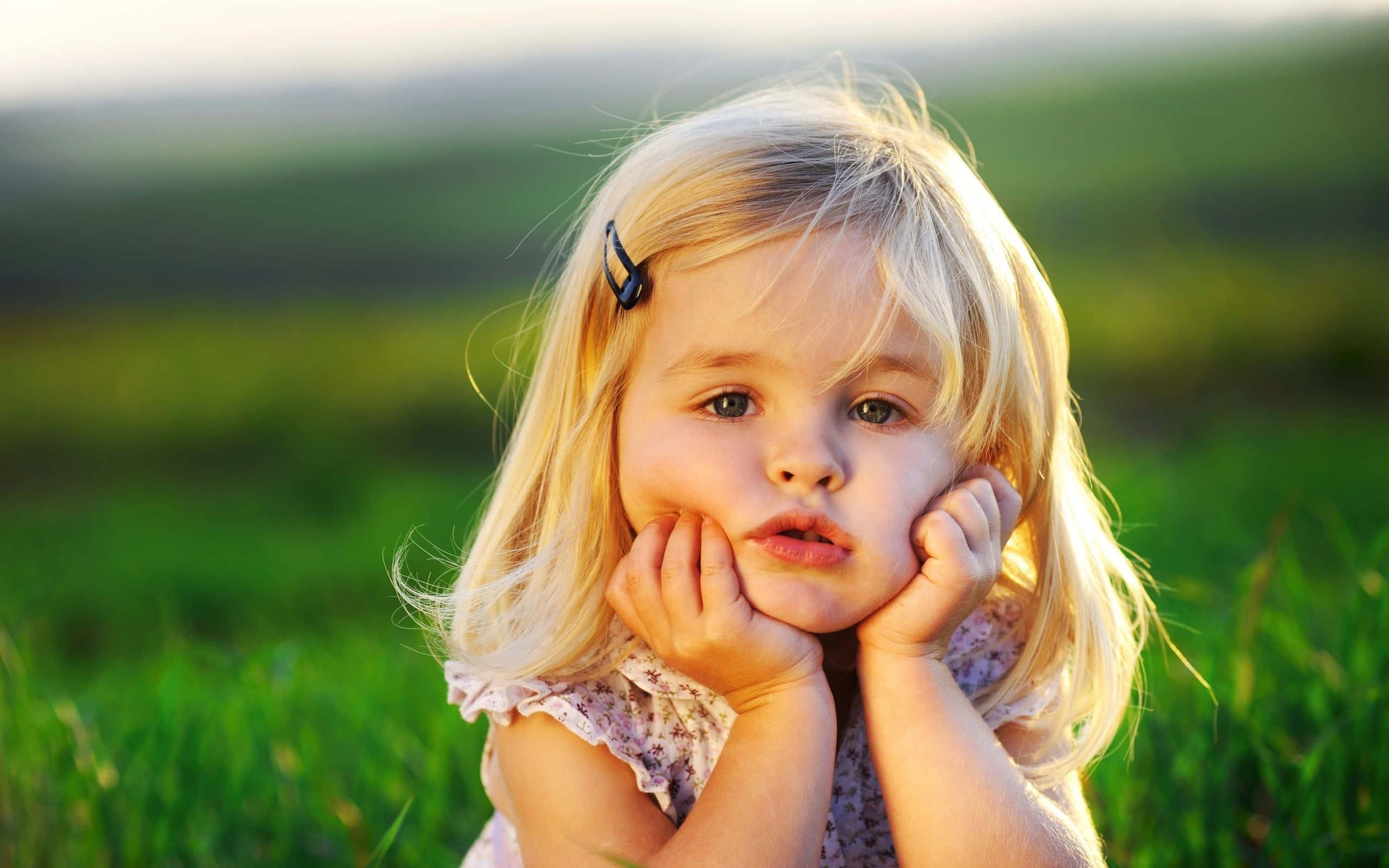 thoughtful toddler, sunlight, green field, 2K Desktop Wallpaper