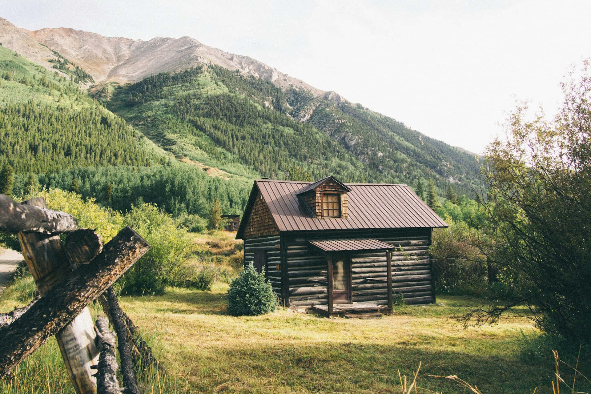 rustic mountain log cabin, sunlit meadow, towering green mountains, Full HD Desktop Wallpaper