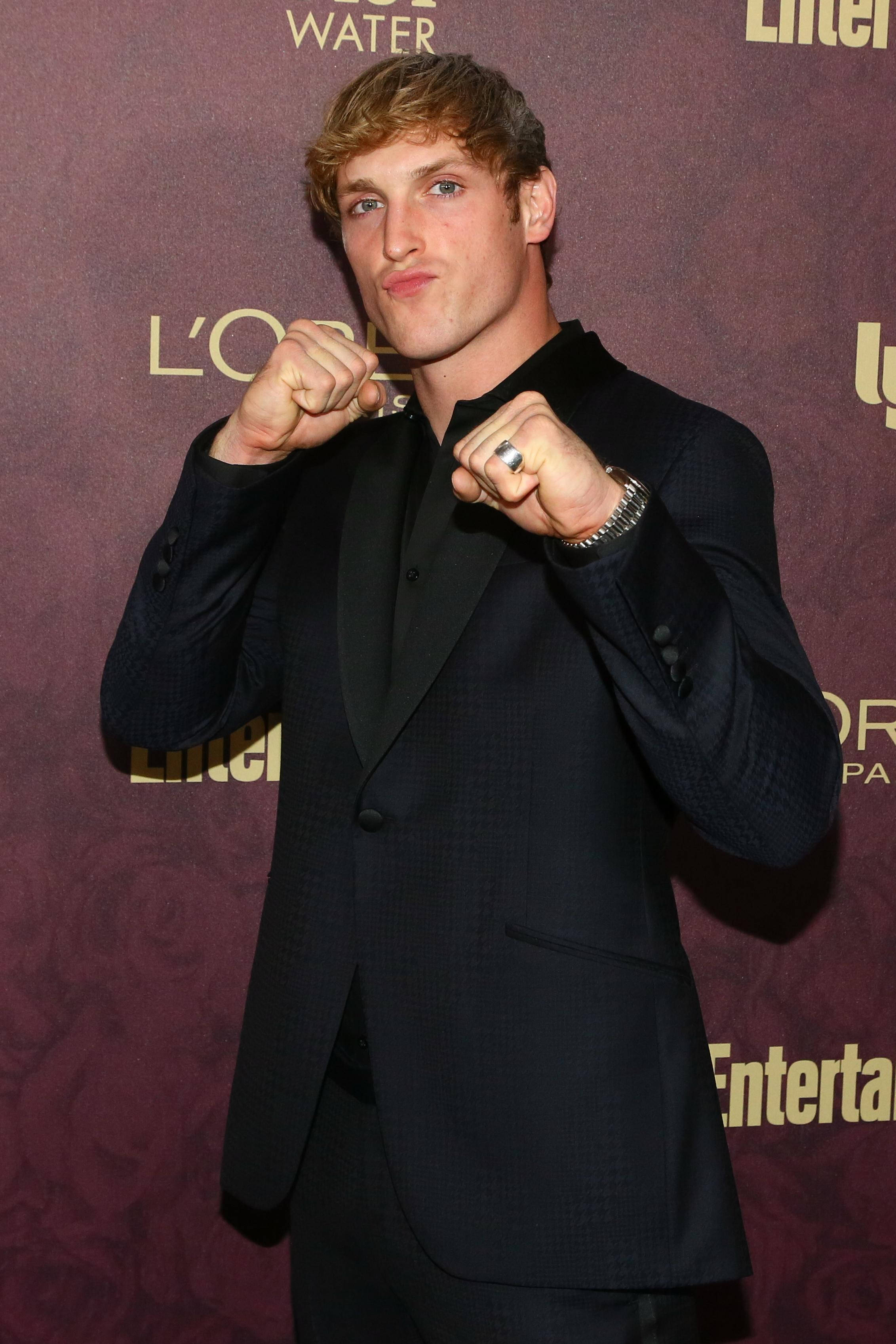 Logan Paul, dark suit, playful boxing pose, 2K Phone Wallpaper