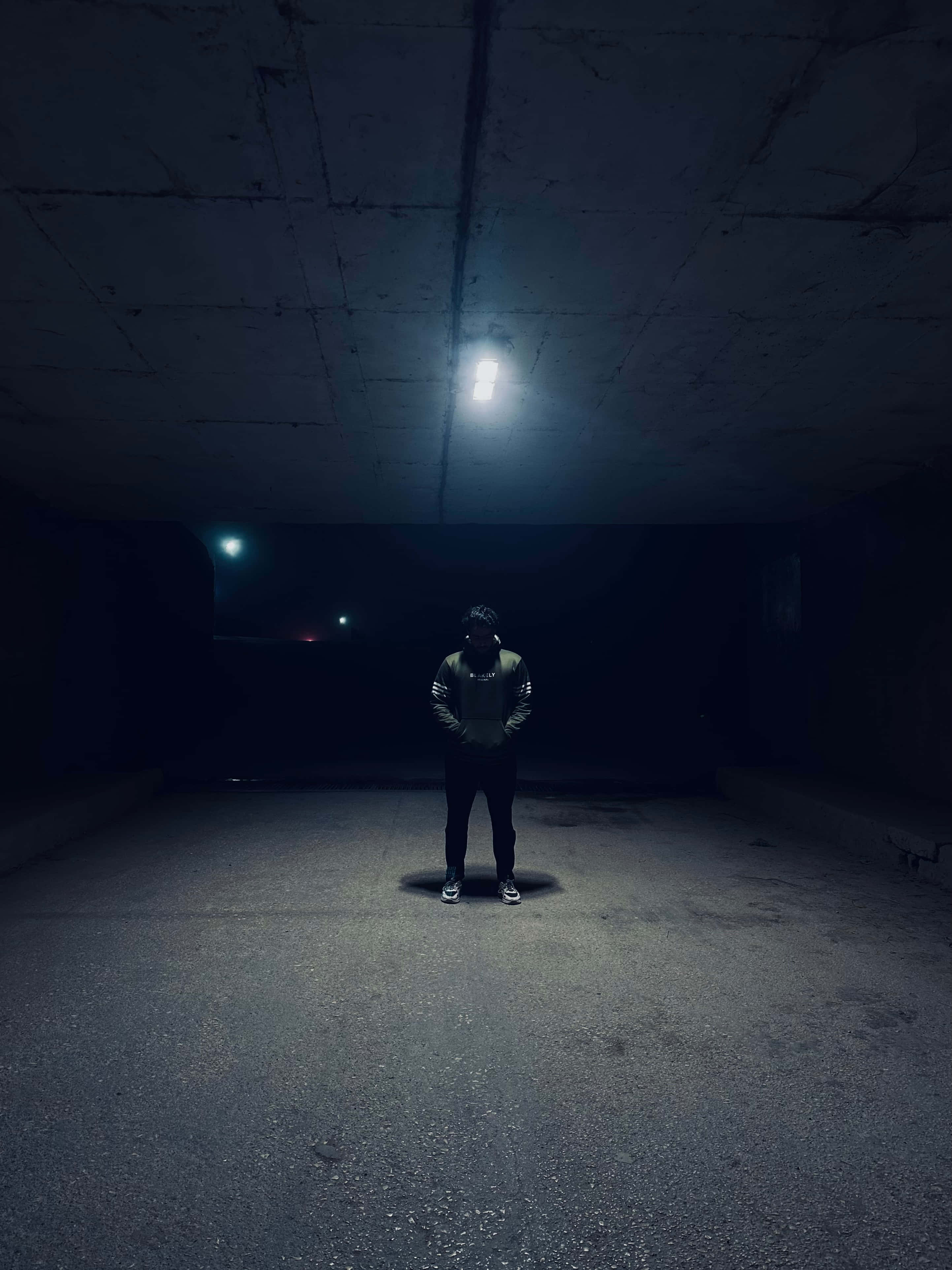 A heartbreak kid, single bright light, dark concrete tunnel, 4K Phone Wallpaper