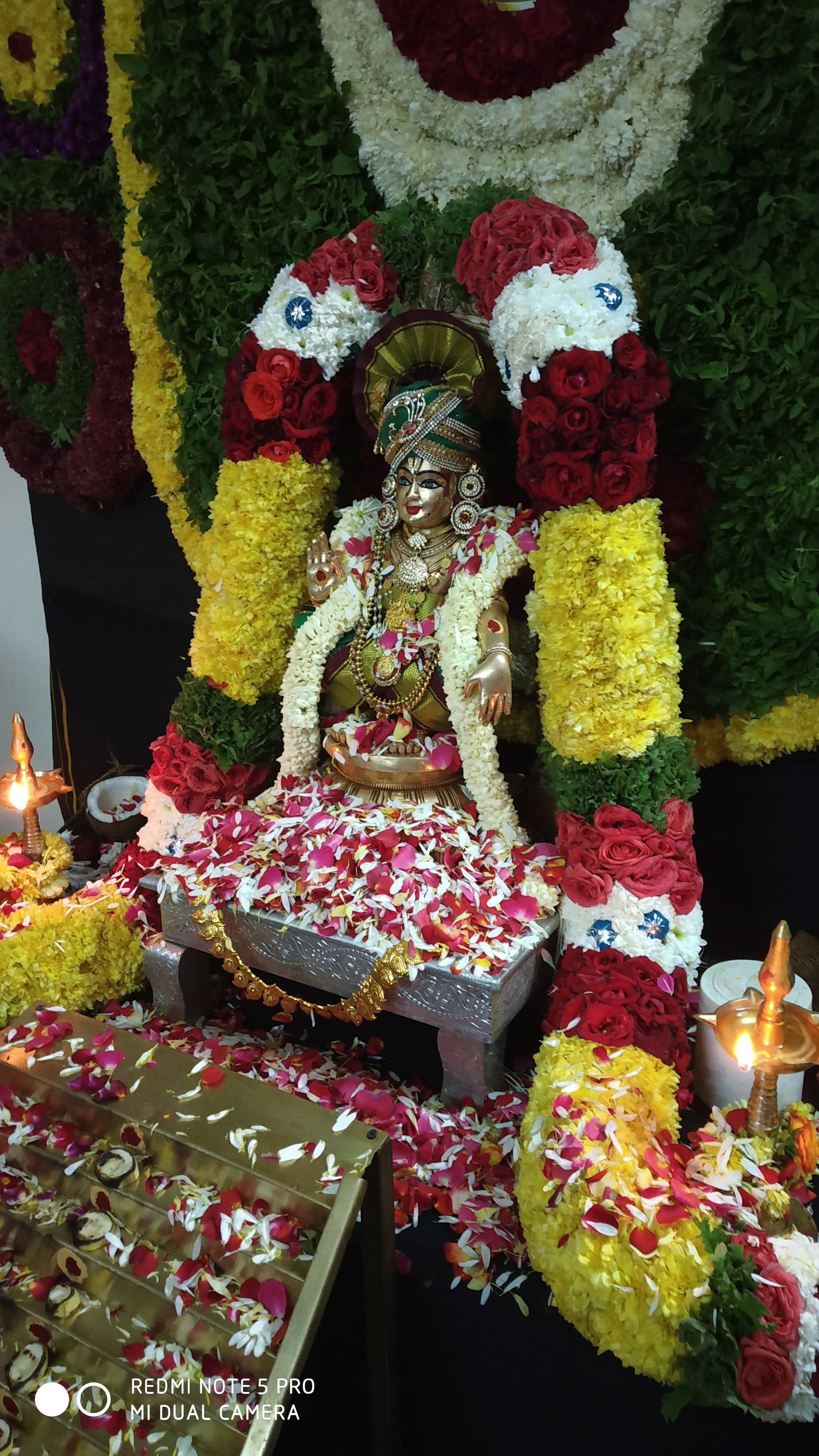 Lord Ayyappa, golden deity statue, red yellow and white floral garlands, 4K Phone Wallpaper