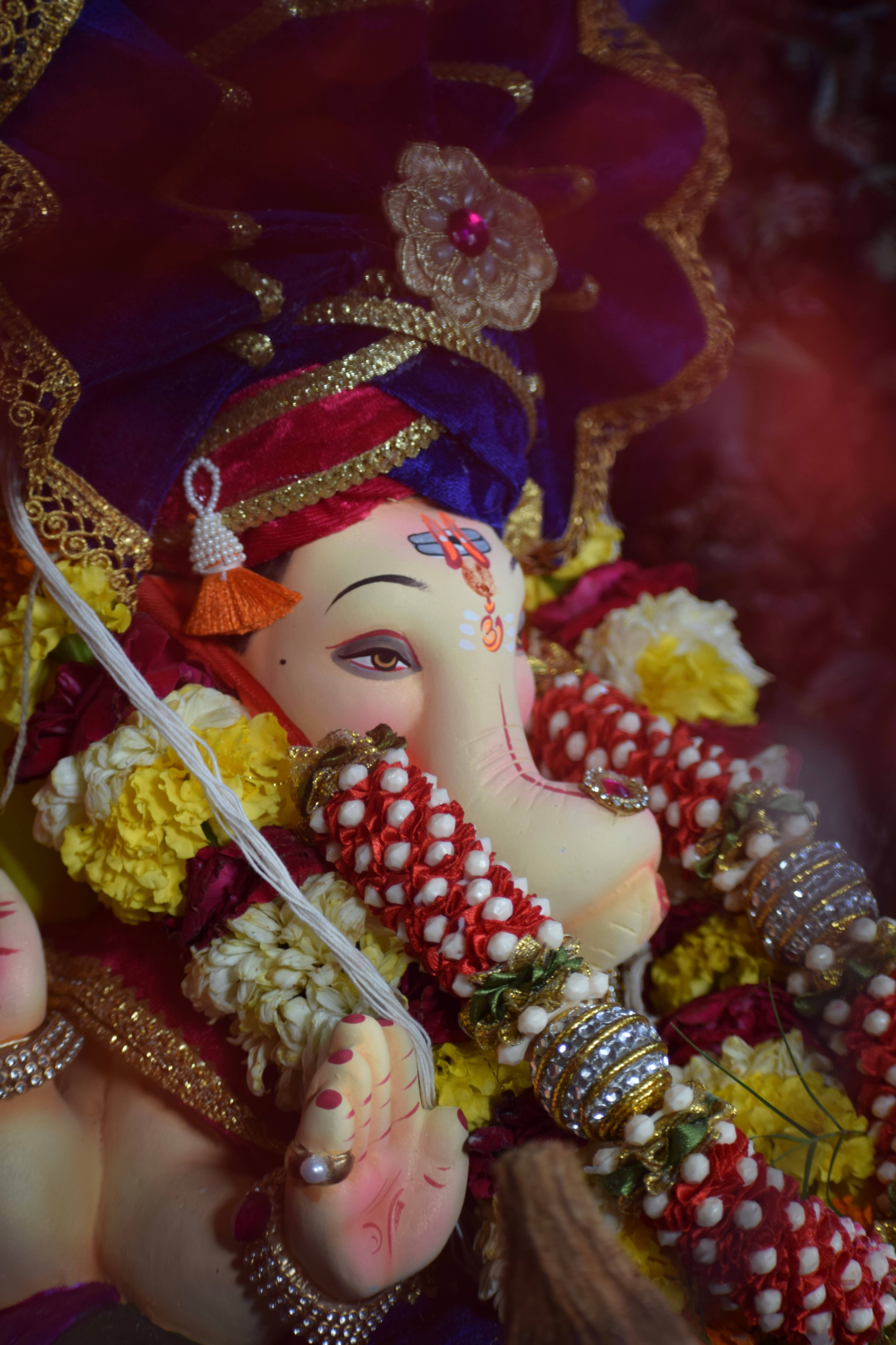 Lord Ganesha, golden embellishments, vibrant marigold garlands, 5K Phone Wallpaper