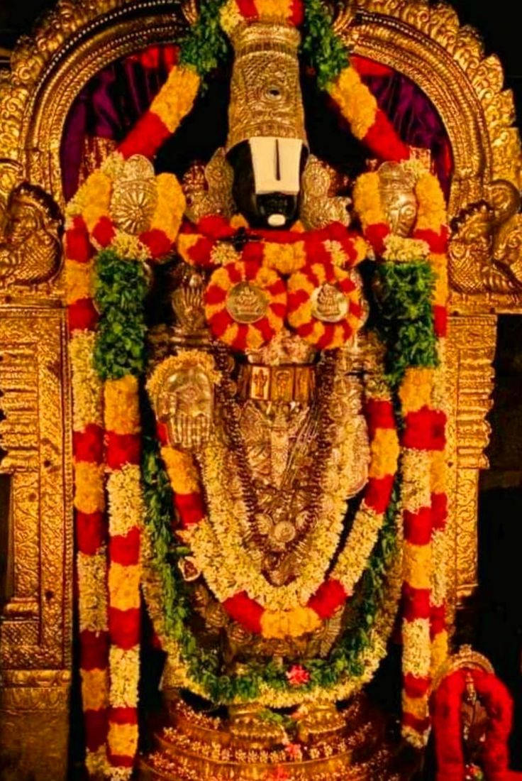 Lord Venkateswara, golden deity statue, vibrant red yellow and green floral garlands, SD Phone Wallpaper