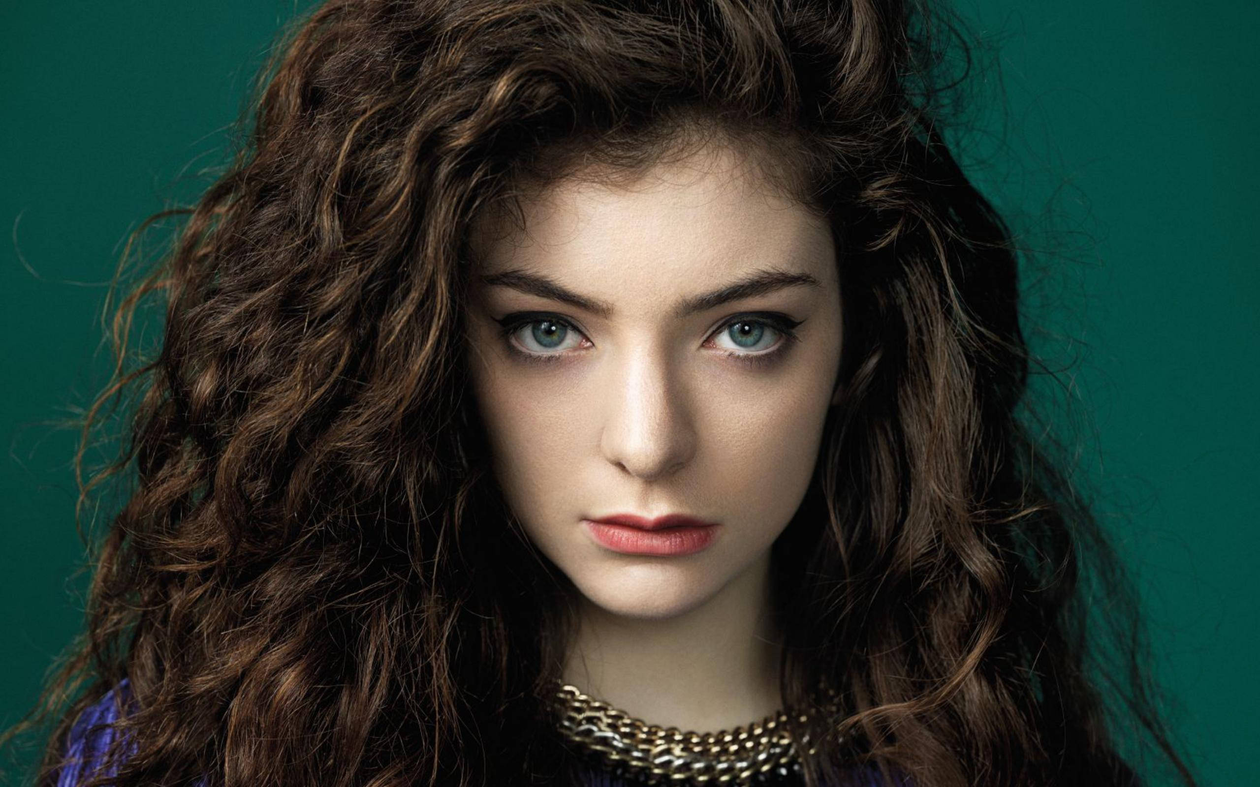 Lorde, voluminous curly brown hair, striking blue eyes, 2K Desktop Wallpaper