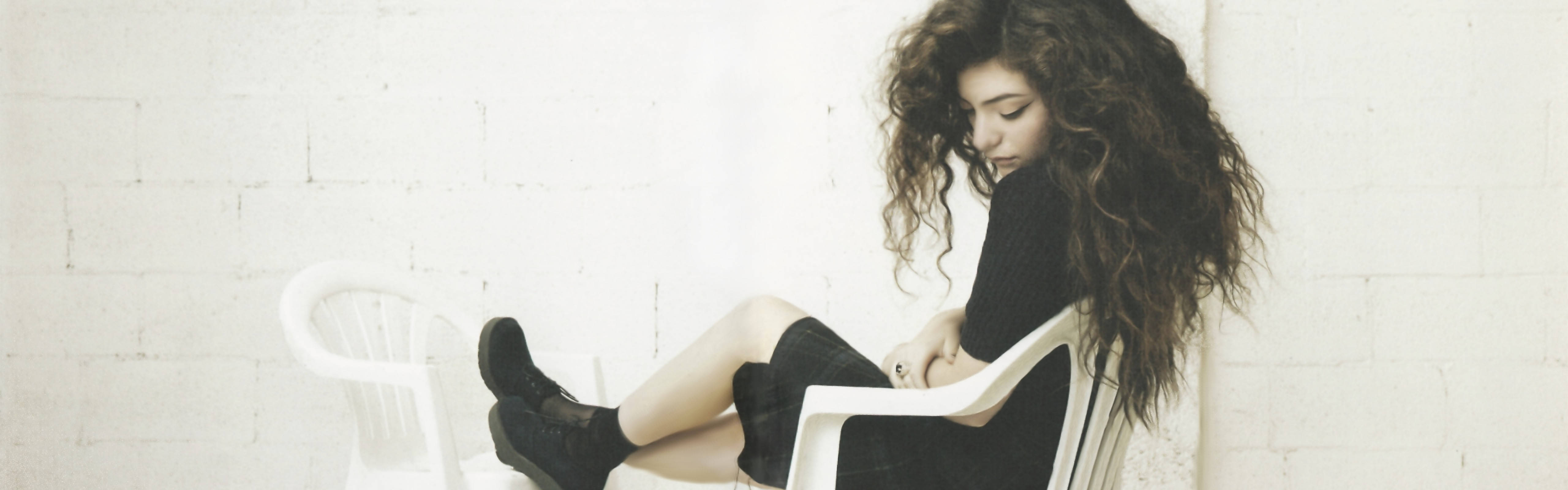 Lorde, white plastic chair, white brick wall, 5K Desktop Wallpaper