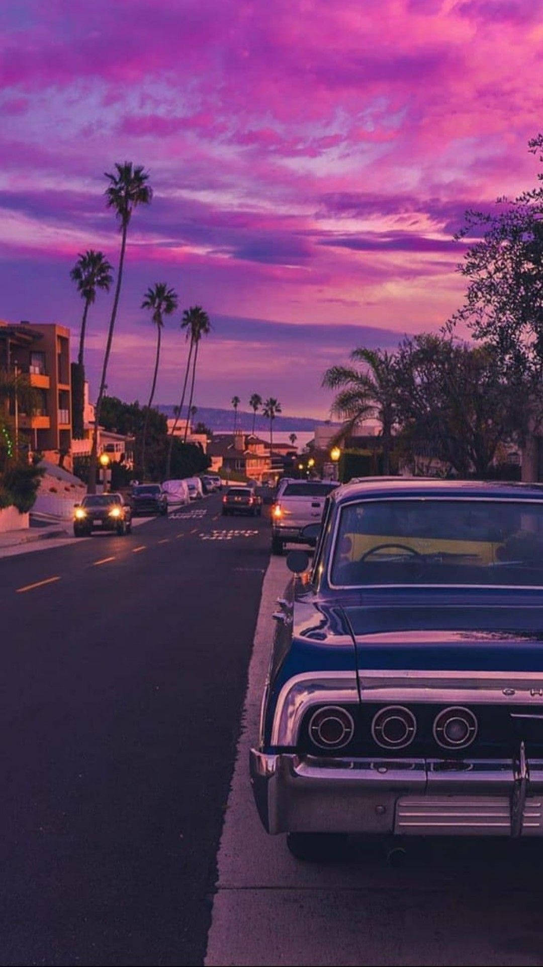 vintage blue car, palm-lined street, vibrant purple and pink sunset sky, Full HD Phone Wallpaper