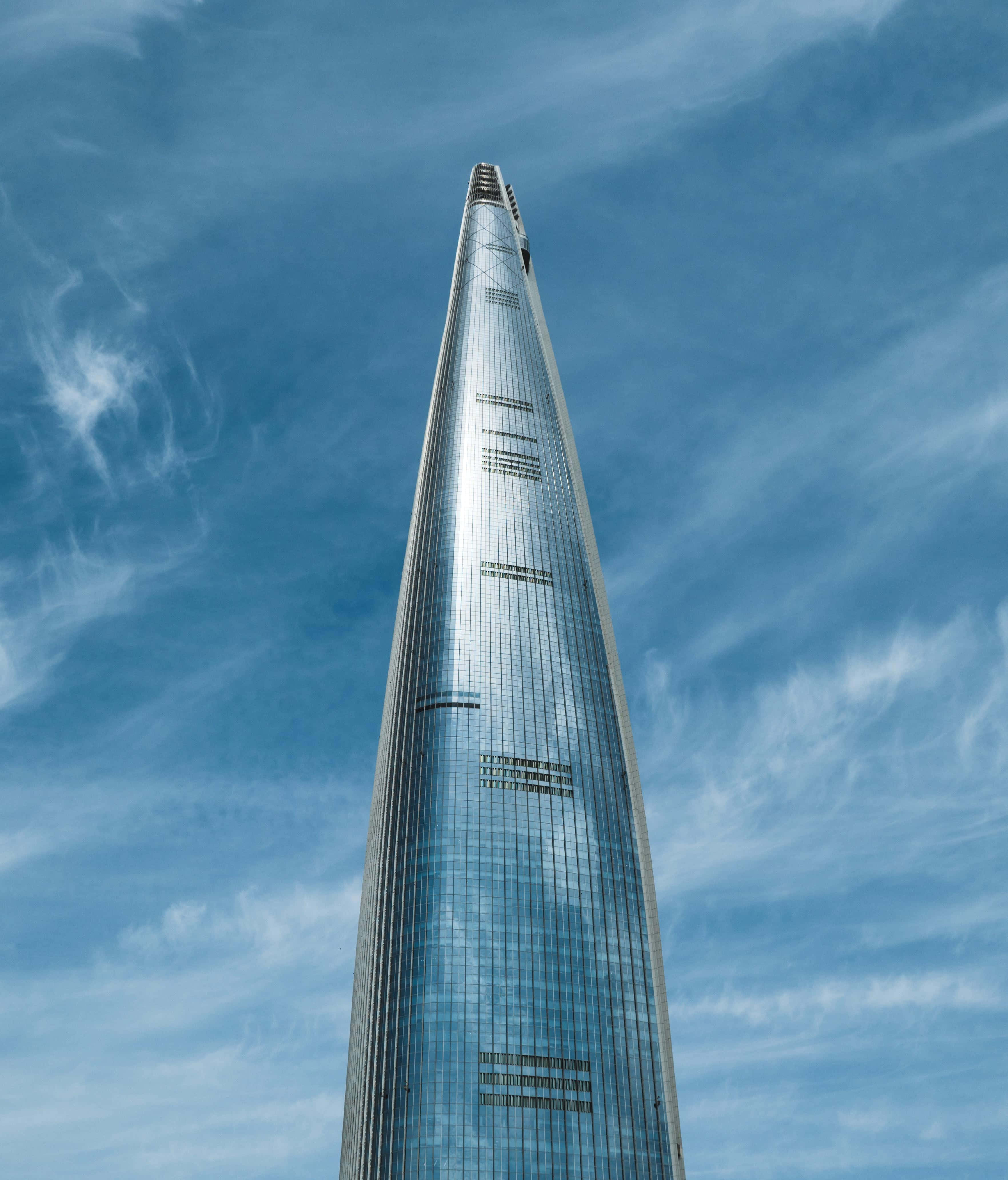 Lotte World Tower, vibrant blue sky, wispy white clouds, 4K Phone Wallpaper
