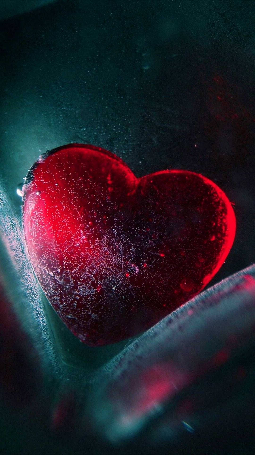 glowing red heart-shaped object, frosty texture, dark teal environment, Full HD Phone Wallpaper