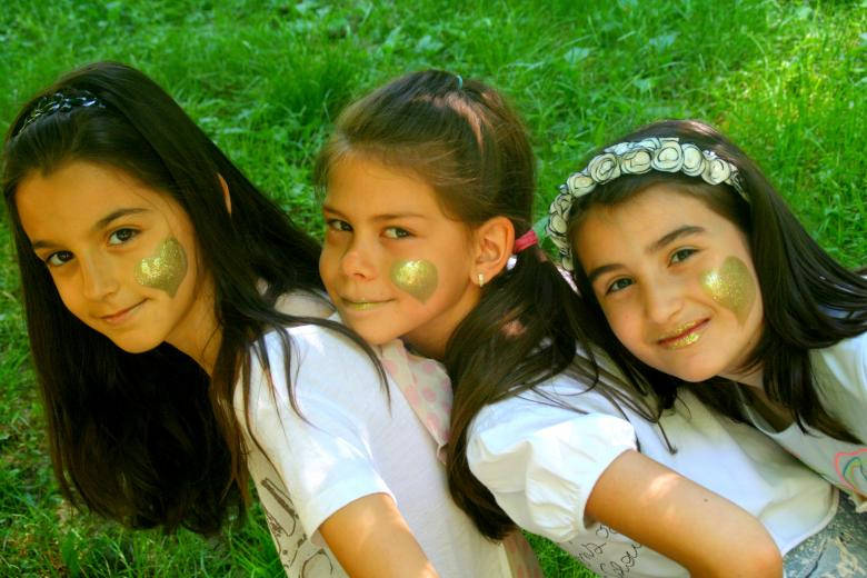 three girls, gold face paint, vibrant green grass, SD Desktop Wallpaper