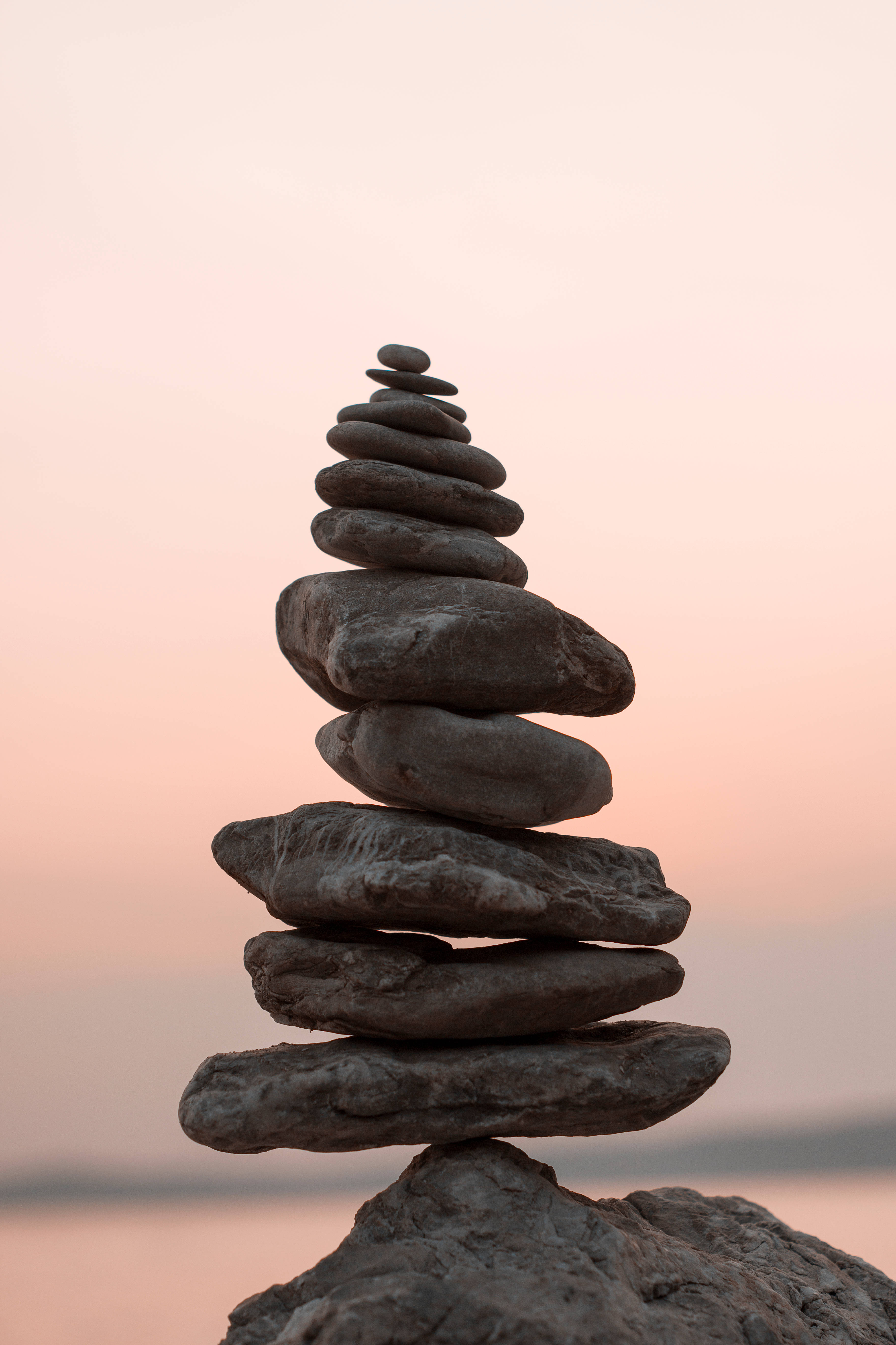 Spiritual Balanced Rocks, smooth river stones, soft pink and peach sunset sky, 5K Phone Wallpaper