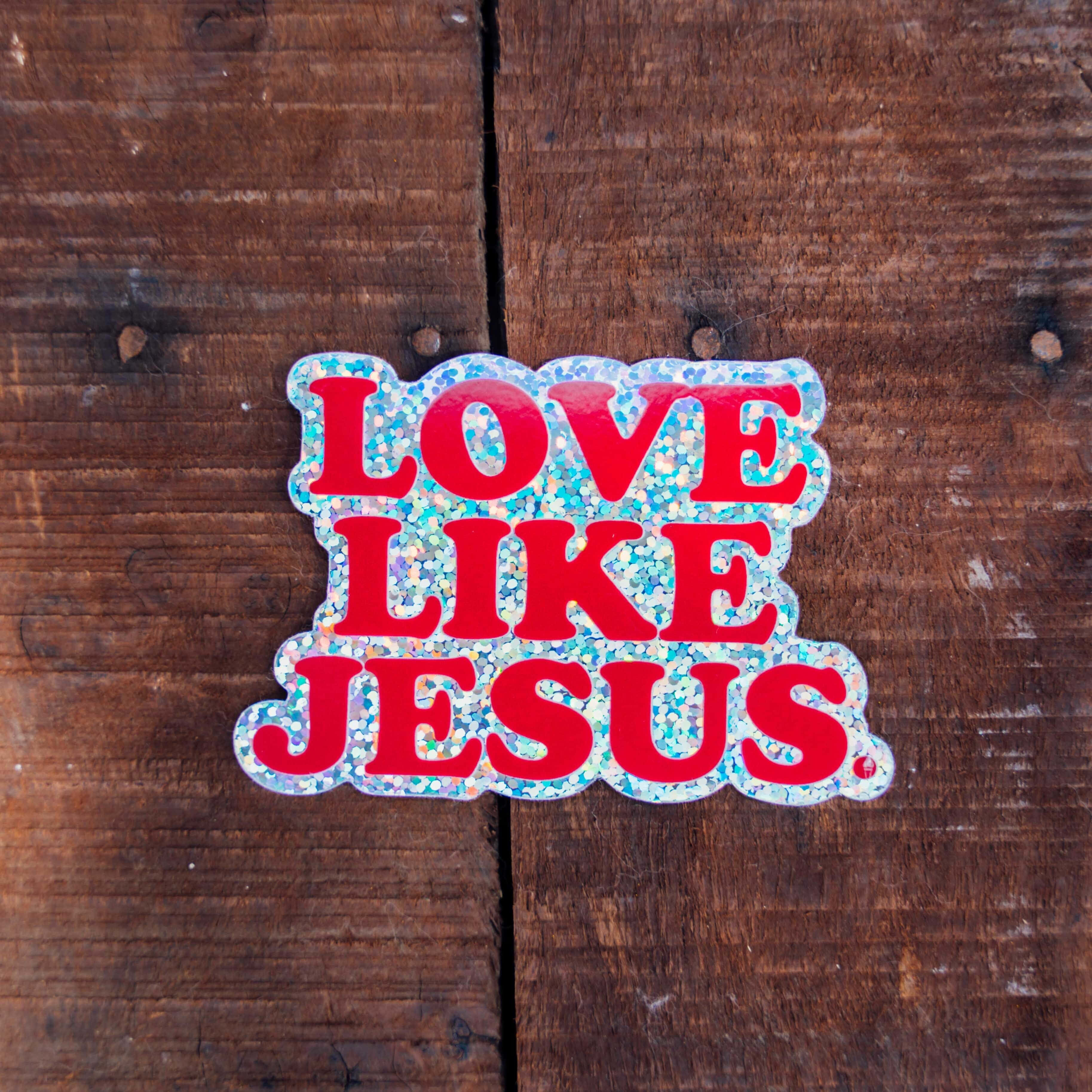 Love Like Jesus, red glittery sticker, weathered brown wooden surface, 2K Desktop Wallpaper