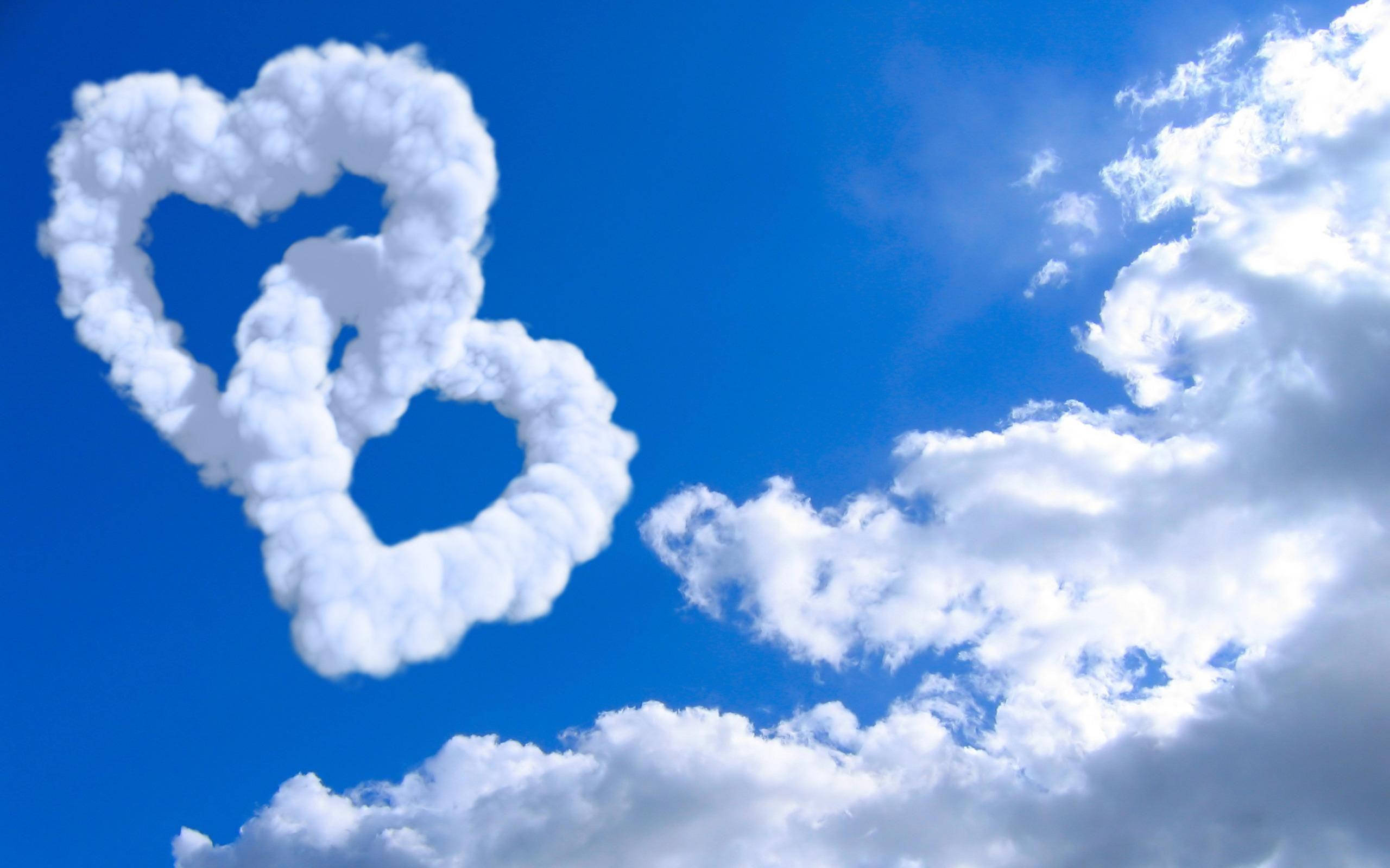 heart-shaped clouds, vibrant blue sky, fluffy white clouds, 2K Desktop Wallpaper