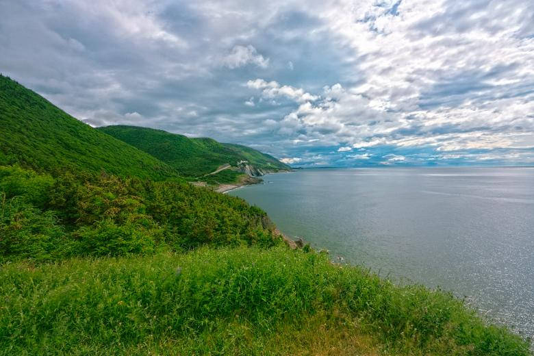 Lush green hills, calm sea, dramatic cloudy sky, SD Desktop Wallpaper