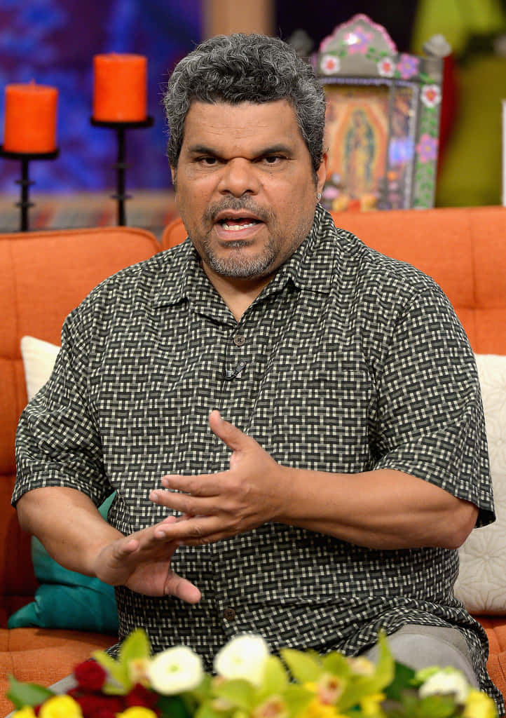 Luis Guzmán, orange couch, colorful studio setting, SD Phone Wallpaper
