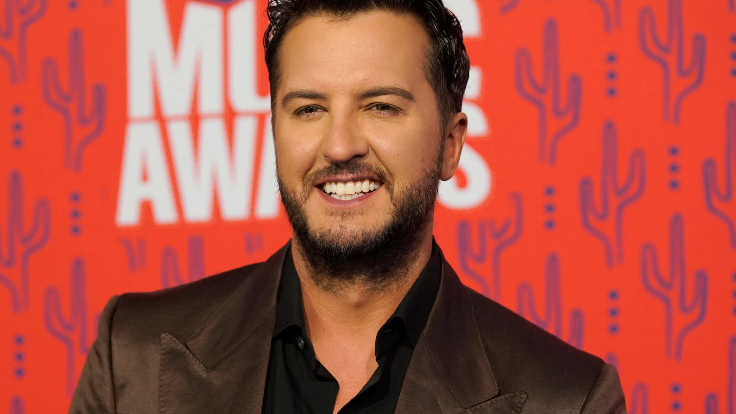 Luke Bryan, brown suit, vibrant red backdrop, 2K Desktop Wallpaper
