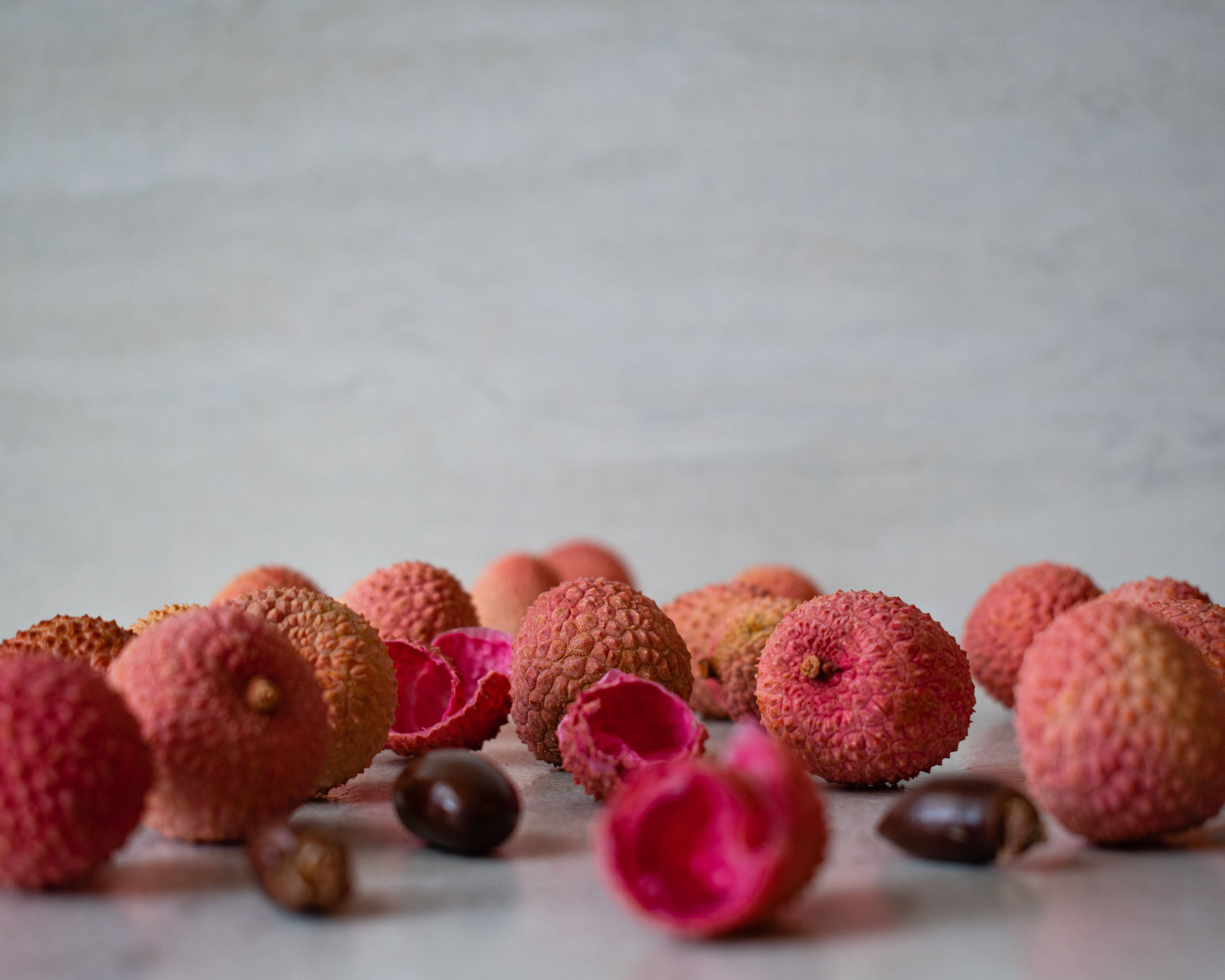 pink lychee fruits, vibrant pink shells, dark seeds, 4K Desktop Wallpaper
