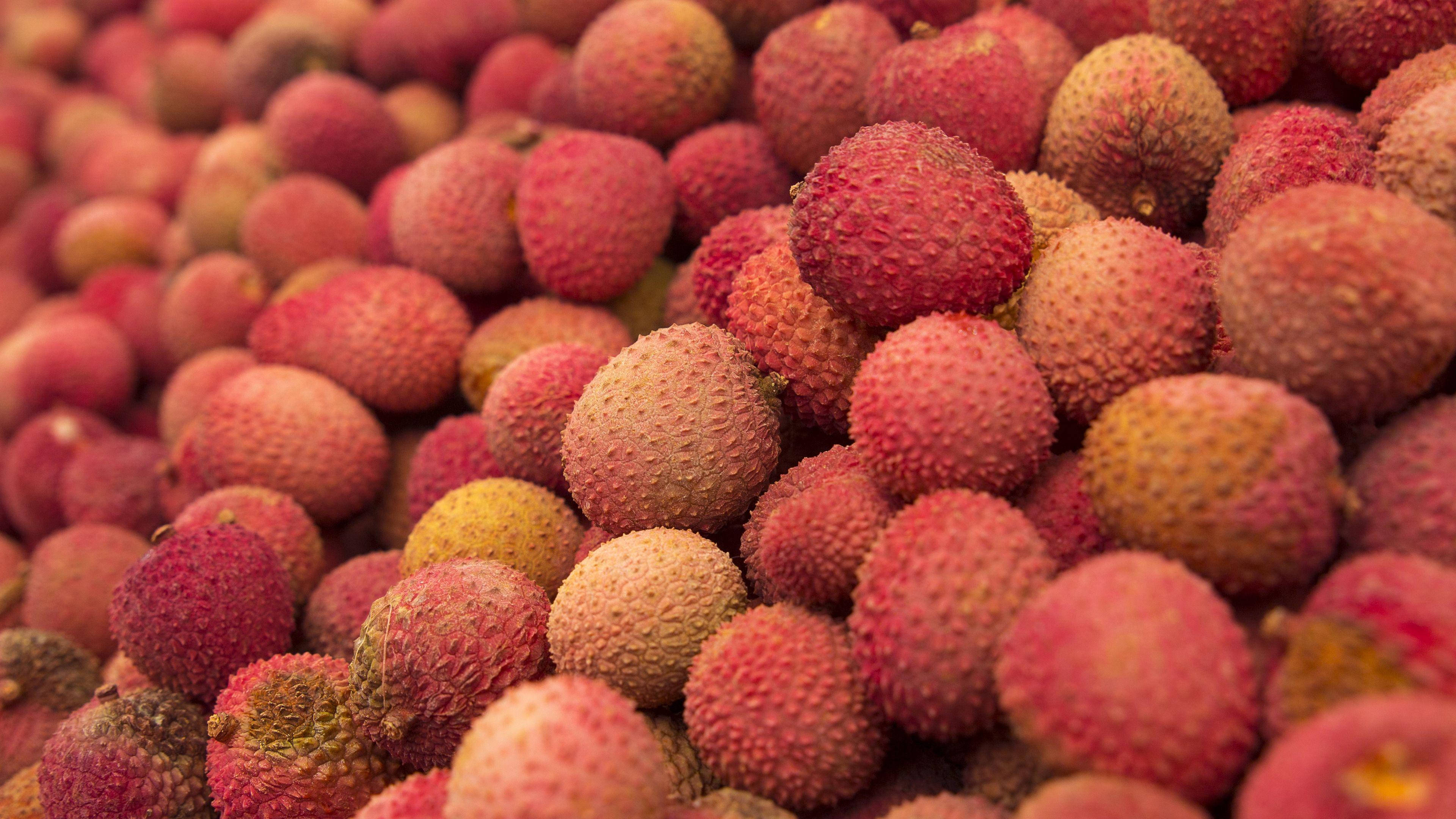 lychee fruits, pinkish-red skin, vibrant close-up, 4K Desktop Wallpaper