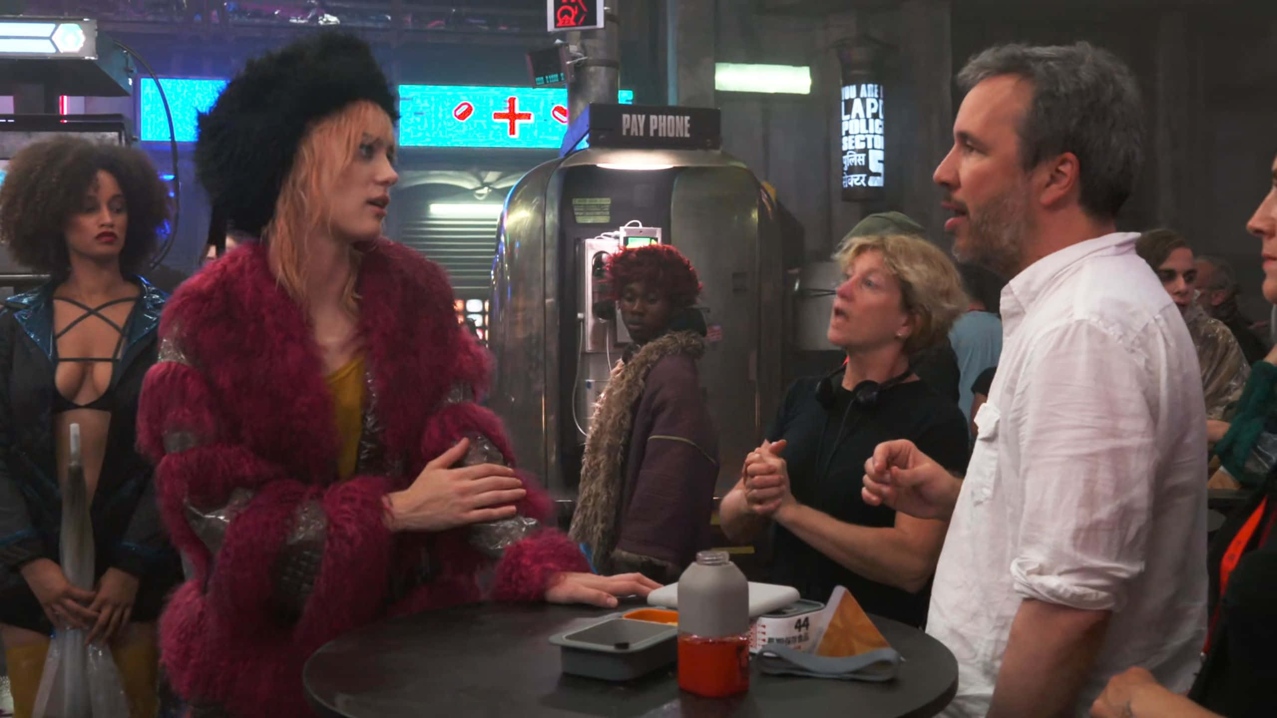 Mackenzie Davis, vibrant pink fur coat, neon-lit futuristic diner, 2K Desktop Wallpaper
