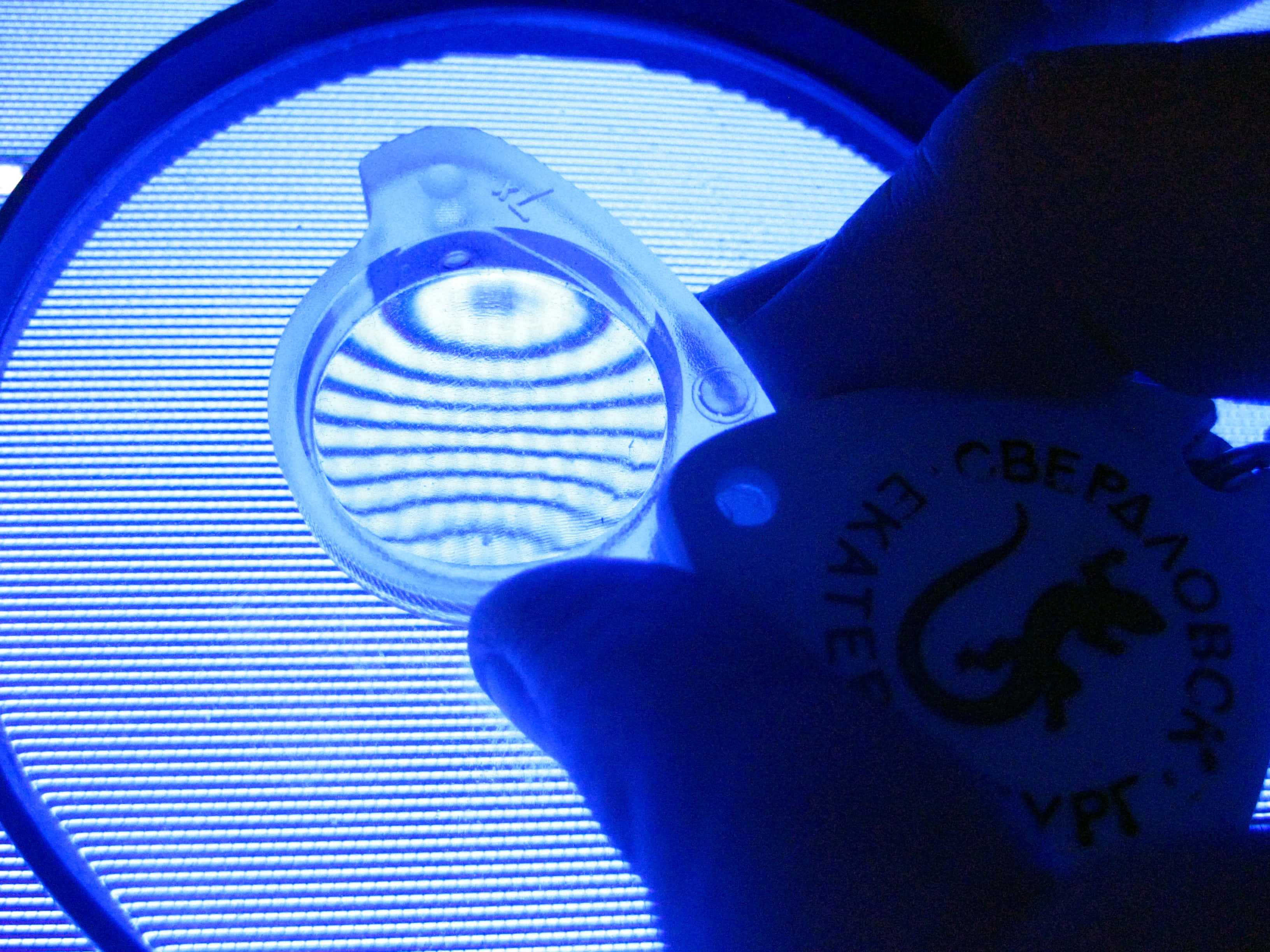 magnifying glass, glowing blue LED panel, concentric ridges, 2K Desktop Wallpaper