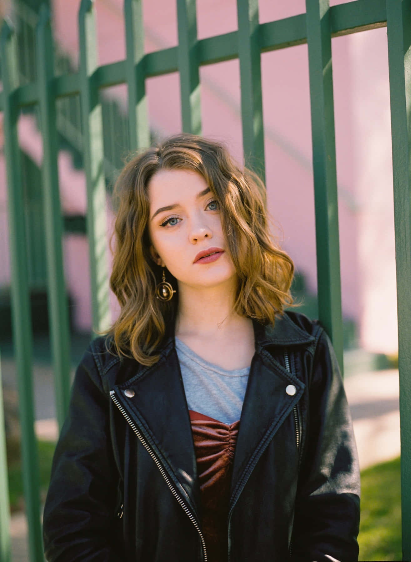 Maisie Peters, wavy brown hair, green metal fence, HD Phone Wallpaper