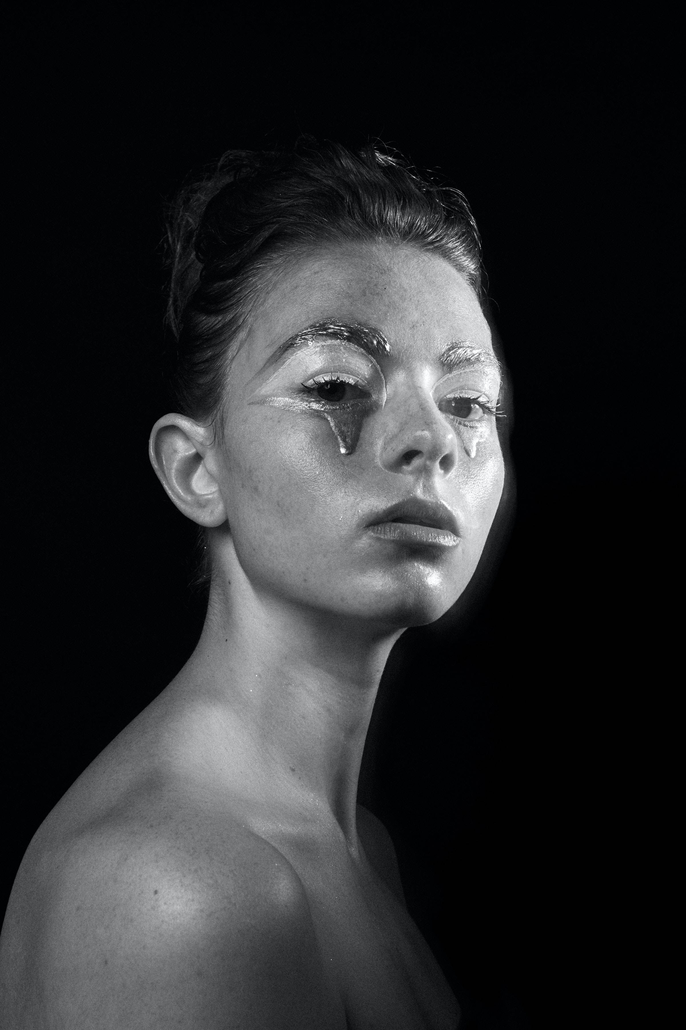 theater makeup, silver metallic tears, black background, 2K Phone Wallpaper