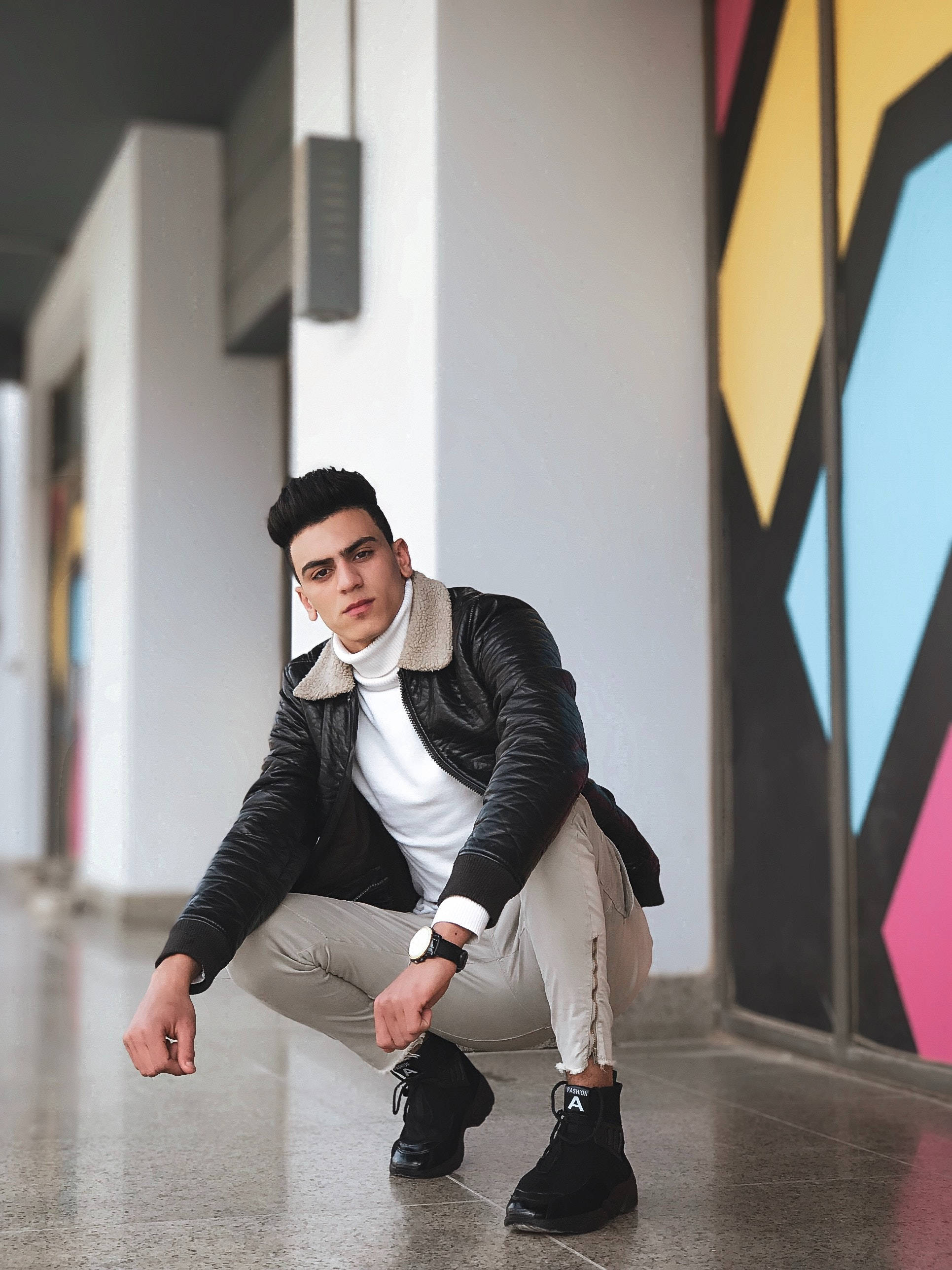 black leather jacket, white turtleneck, colorful geometric mural wall, 2K Phone Wallpaper