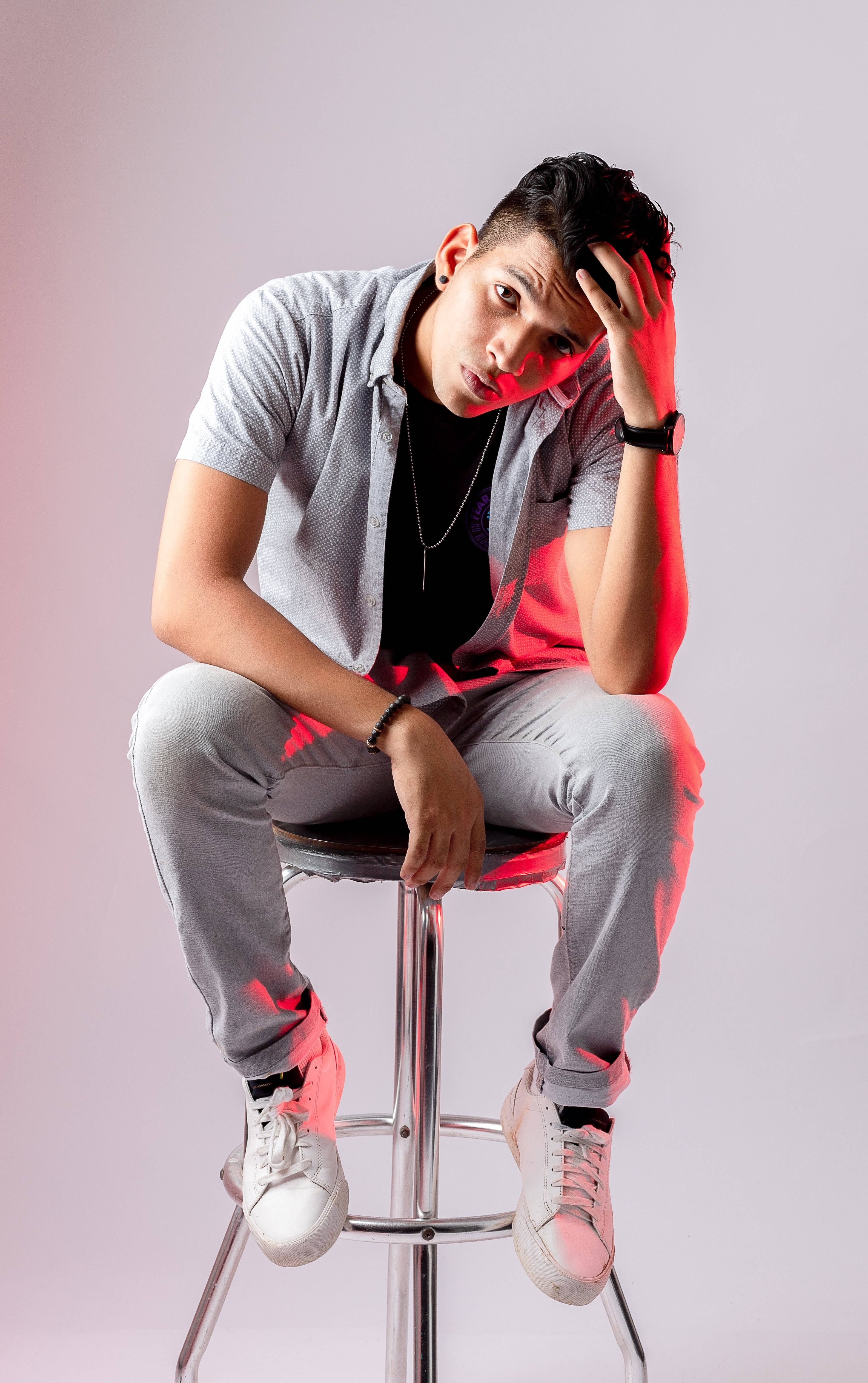 male model, grey outfit, soft pink and red lit studio backdrop, 4K Phone Wallpaper